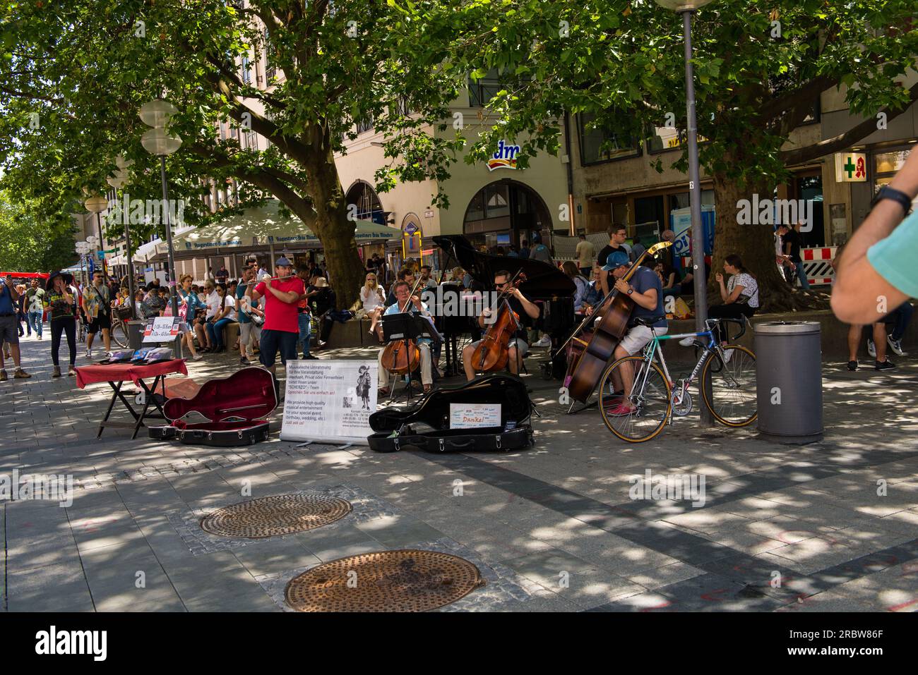 Monaco di Baviera, Germania - 7 luglio 2023: Un'orchestra di strada suona musica nella zona pedonale del centro città Foto Stock
