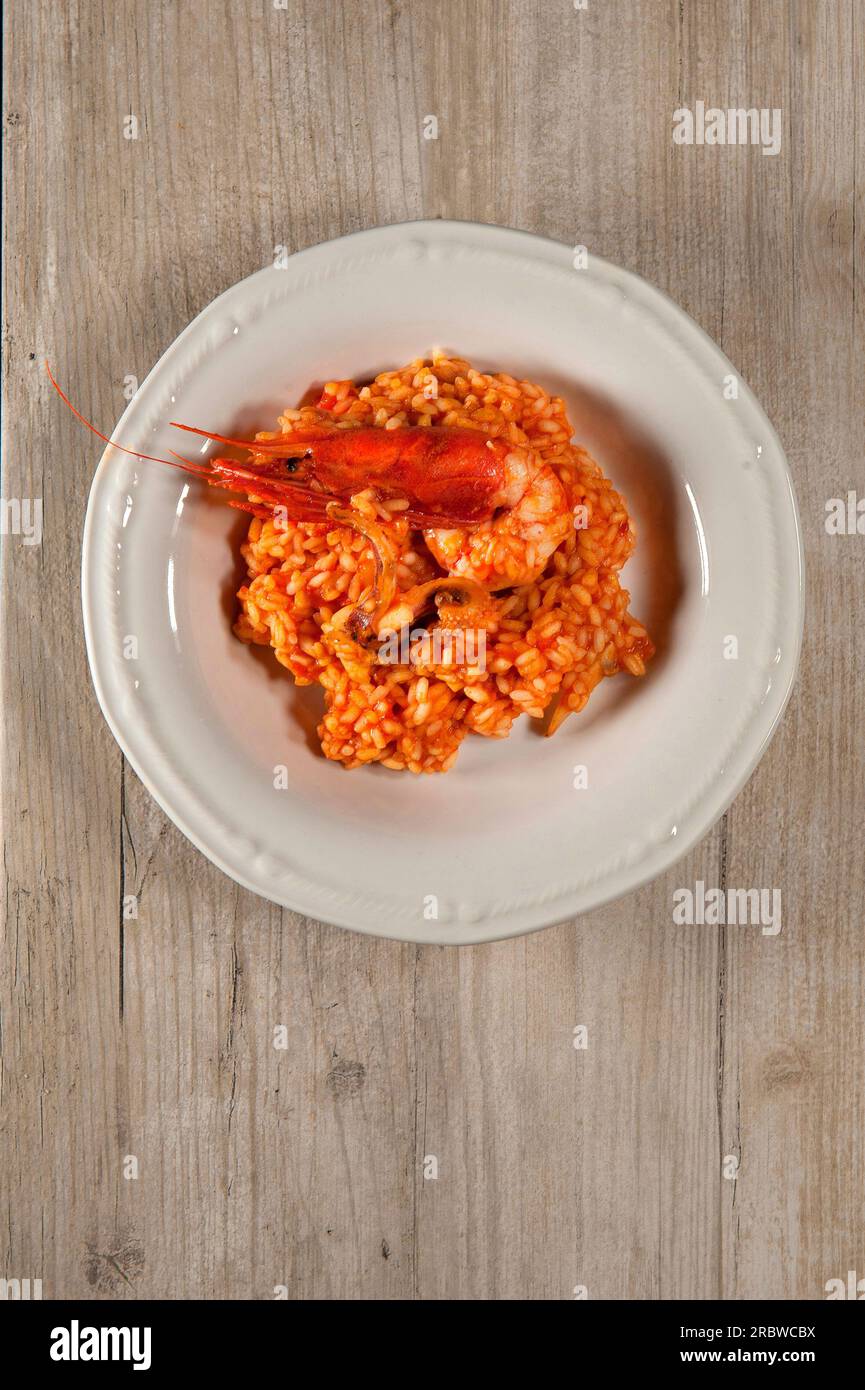 Risotto con gamberoni rossi, calamari, filetti di pesce, pomodoro. Dopo la cottura Foto Stock
