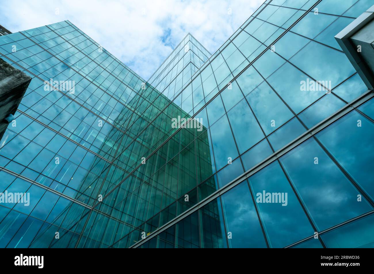 Moderno edificio di uffici in vetro verde sostenibile. Vista esterna dell'architettura dell'edificio in vetro della sede centrale. Edificio a basso consumo energetico. Foto Stock
