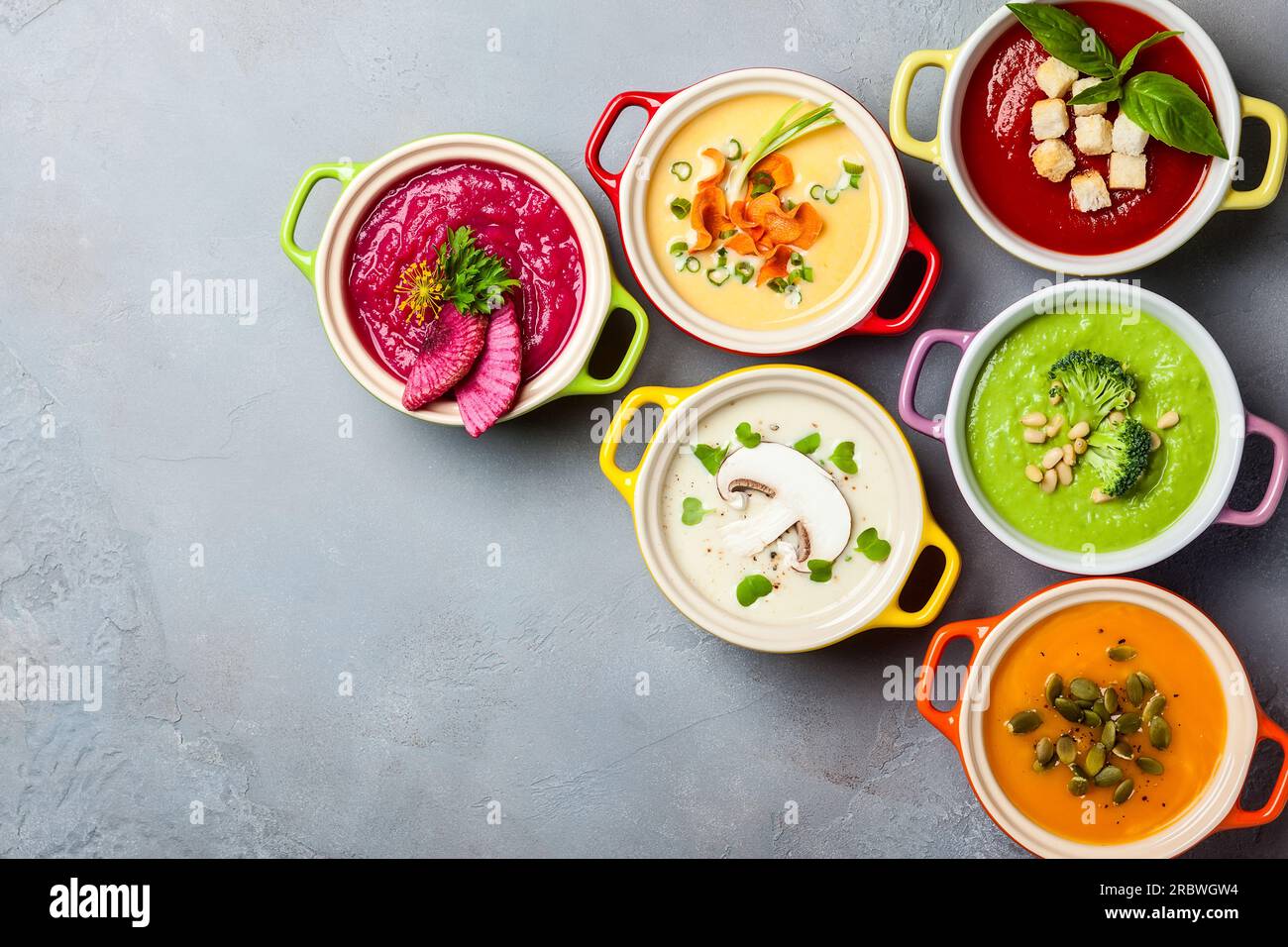 Varieta' di minestre di verdure colorate con panna in pentole piccole. Vista dall'alto. Concetto di alimentazione sana o cibo vegetariano. Foto Stock