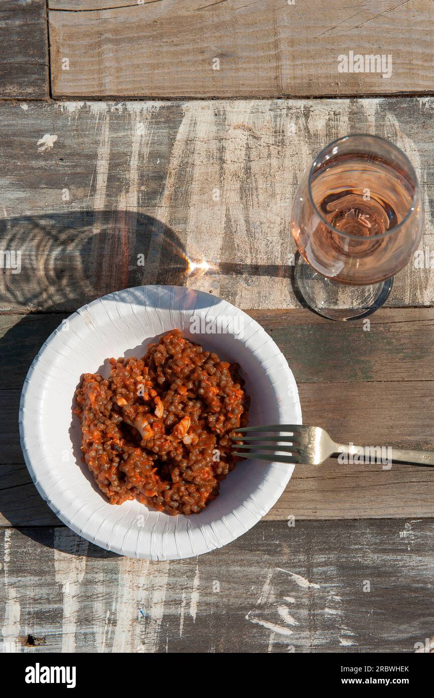 Fregola con pomodori e ragù di pesce (pasta sarda a forma di palla) e bicchiere di vino rosato, Sardegna, Italia, Europa Foto Stock