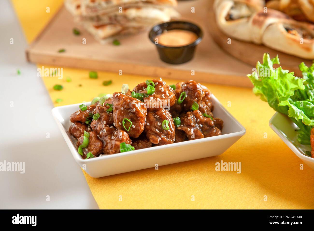 Pollo coreano con semi di sesamo e cipolle verdi. Foto Stock