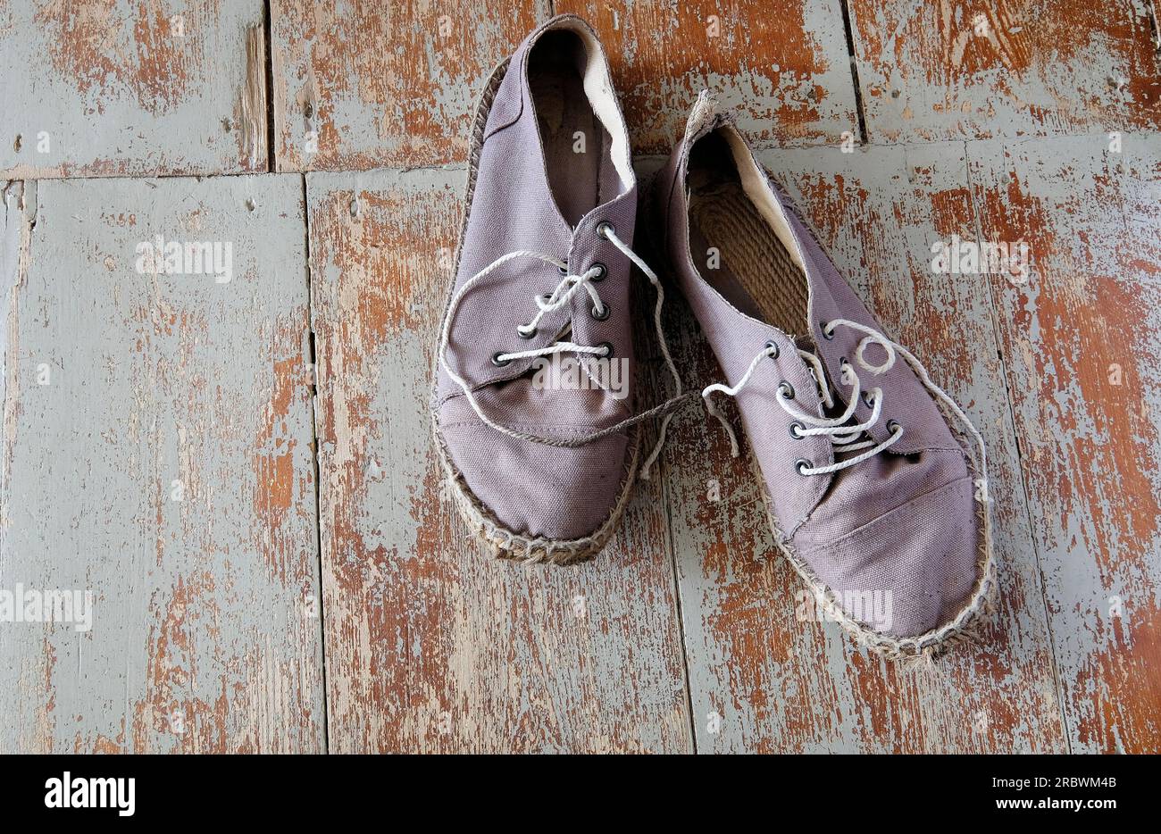 scarpe in tela scruffa grigia su pavimenti verniciati usurati Foto Stock