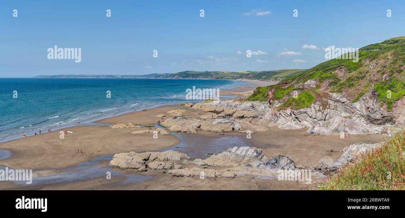 E' solo una delle tante baie pittoresche della Cornovaglia, in Inghilterra. Whitsand Beach è un tratto di sabbia di sei chilometri circa con uno sfondo roccioso rurale. Foto Stock