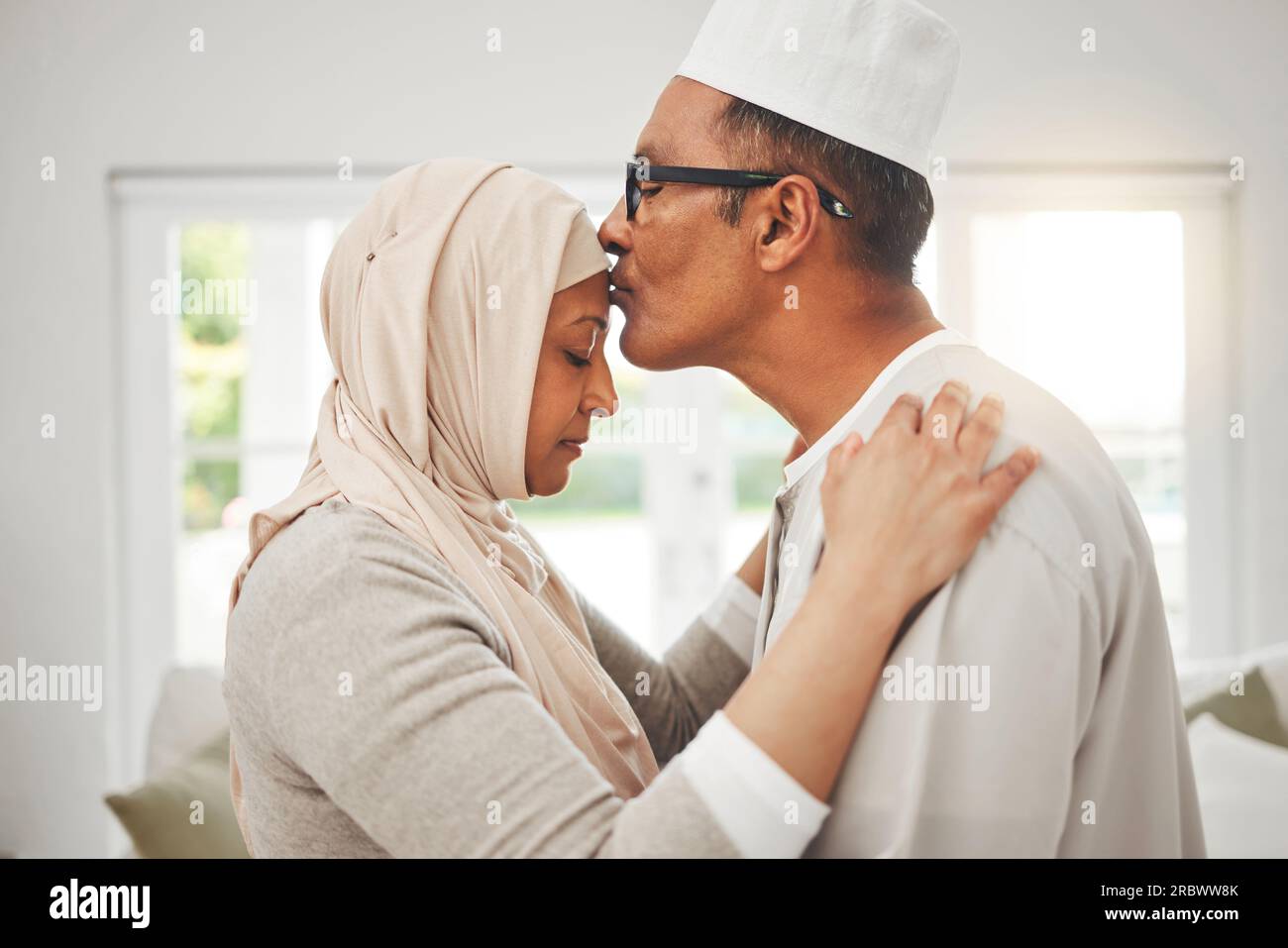 Casa, coppia musulmana anziana e bacio sulla fronte, musica danza lenta e legame per amore, fiducia e cura con gentilezza. Impegno, uomo islamico e arabo Foto Stock