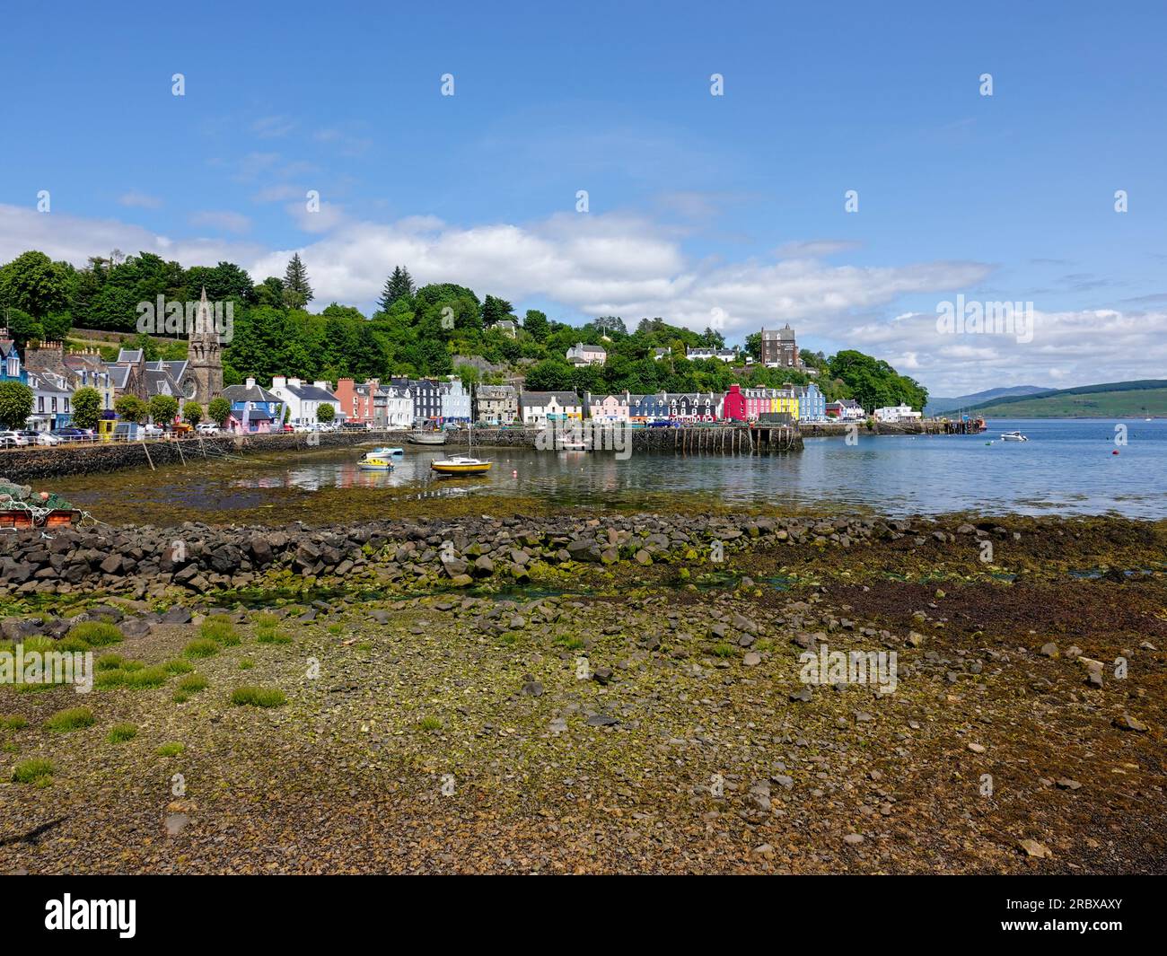 Colorato villaggio isolano, città di Tobermory con bassa marea in una bella giornata estiva, Ebridi interne, Isola di Mull, Scozia, Regno Unito. Foto Stock