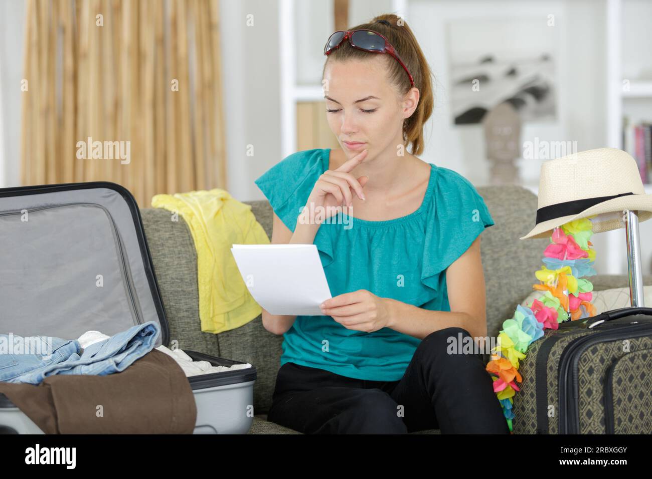 donna che sta facendo la lista delle valigie per le vacanze estive Foto Stock