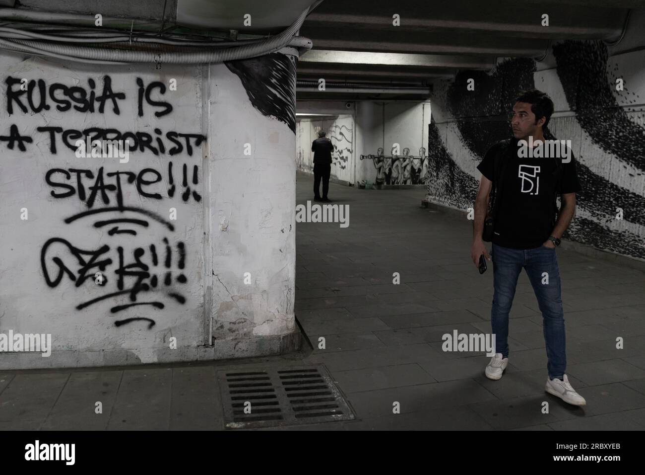 I turisti controllano il muro con graffiti sulla guerra russa. Foto Stock