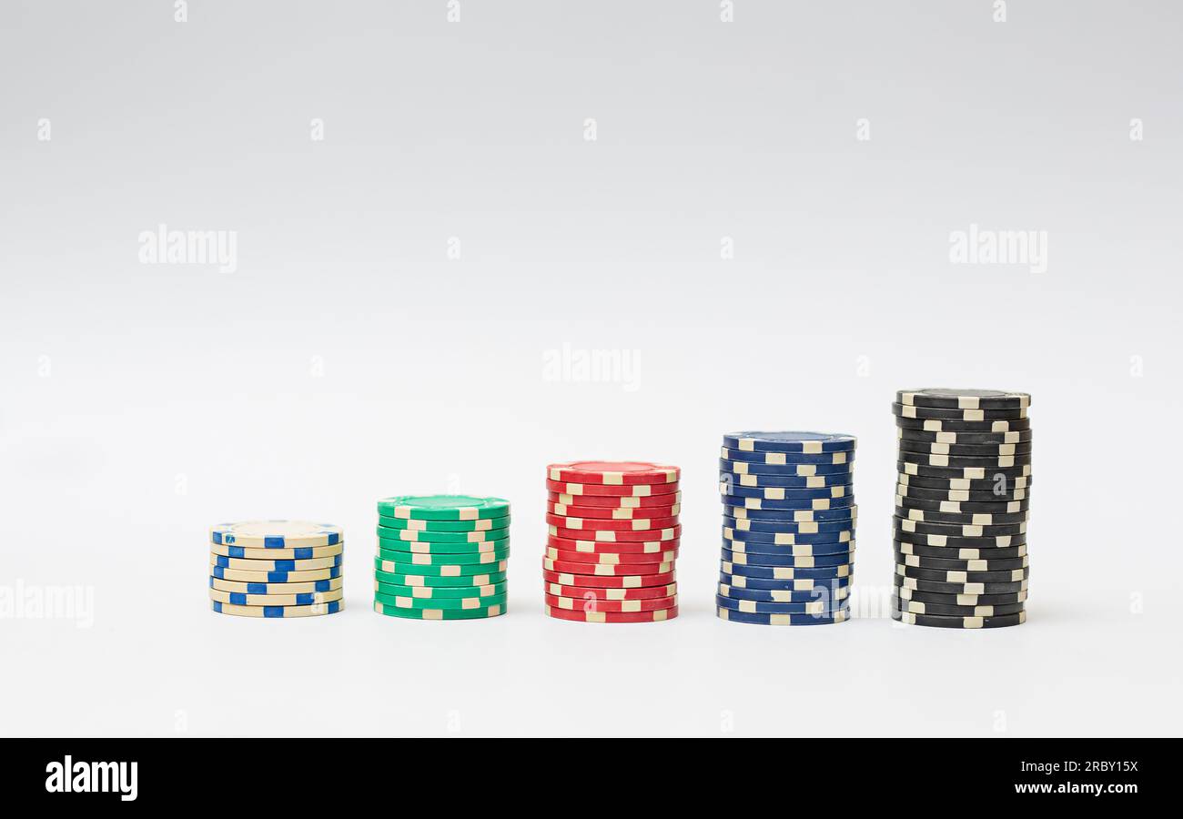 Chip in plastica per casinò impilati su sfondo bianco. Gioco di poker. Foto Stock