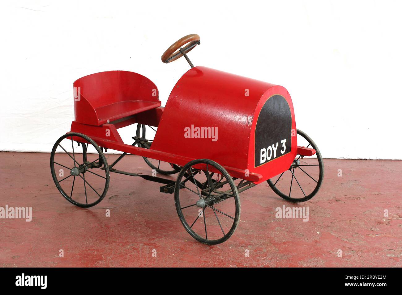 Un'antica carrozza rossa per bambini Foto Stock