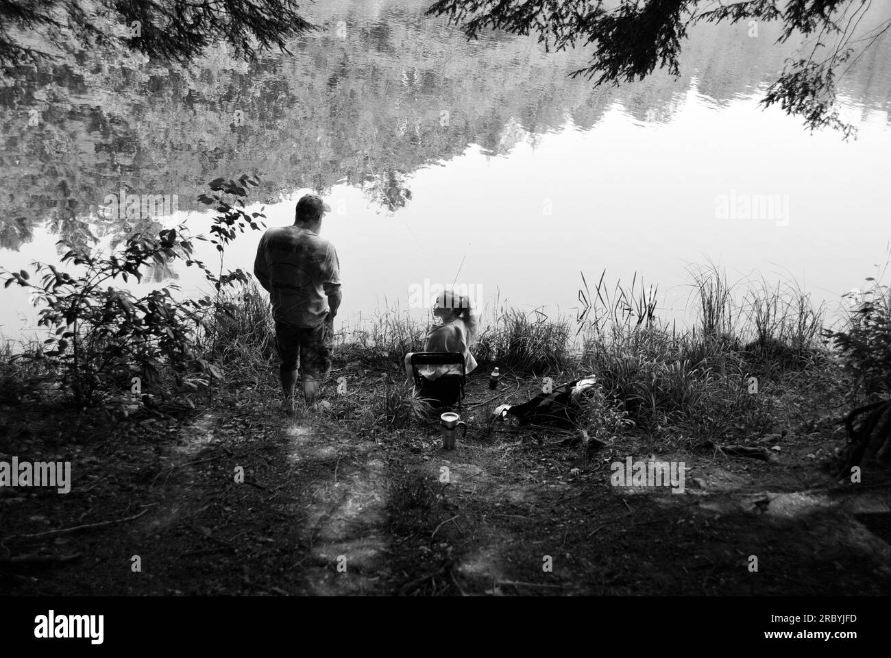 Un uomo e sua figlia pescano accanto ad un lago in Virginia, USA. Foto Stock