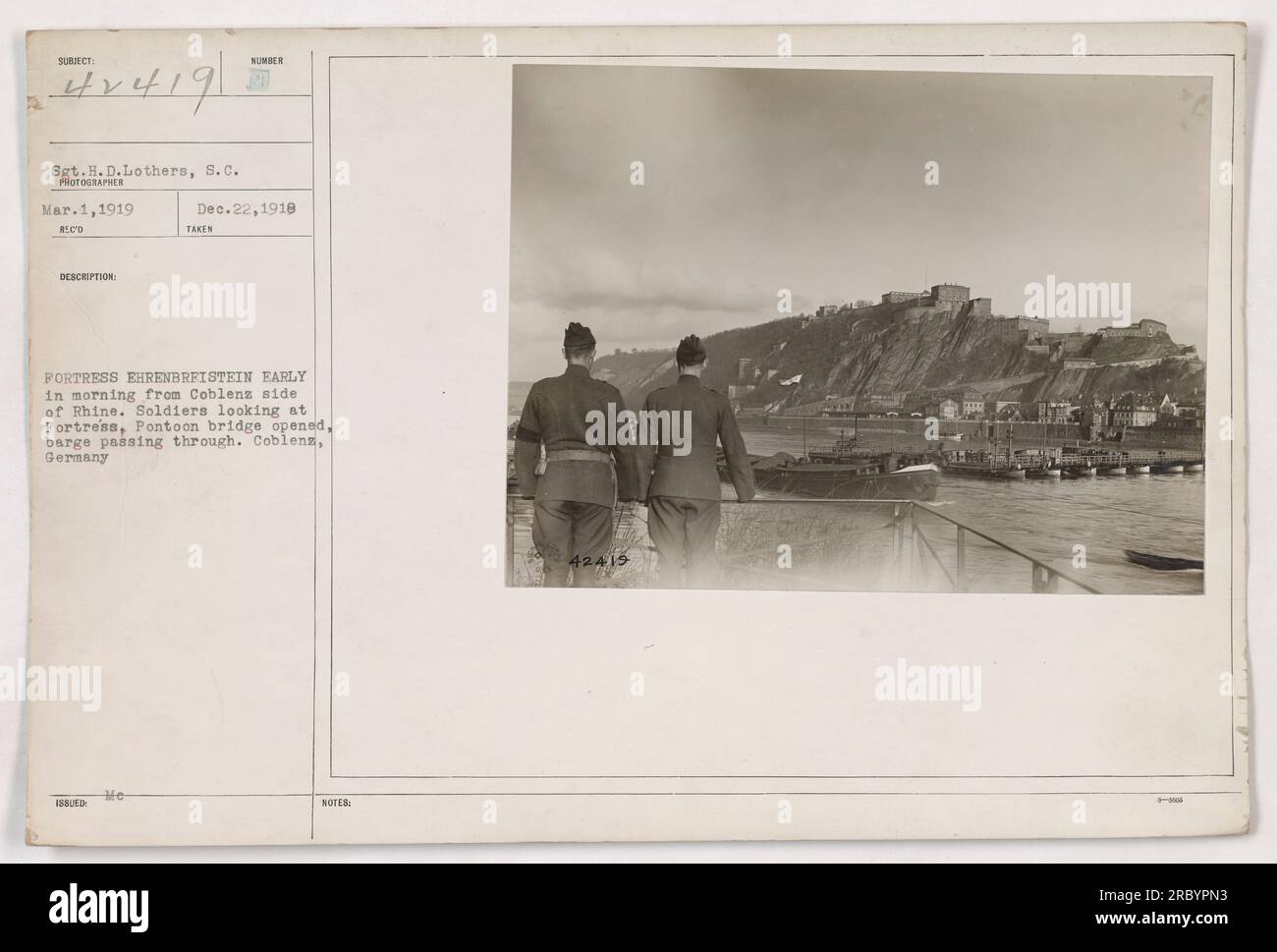 Soldati che osservano la fortezza di Ehrenbreitstein dal lato di Coblenz del Reno la mattina presto. Un ponte di pontone è aperto e una chiatta passa attraverso. La foto, scattata dal sergente H.D. Lothers of the S.C., fa parte della collezione di attività militari americane durante la prima guerra mondiale. Foto Stock