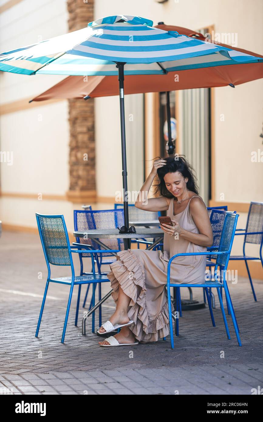 Donna con smartphone in una caffetteria all'aperto sulla terrazza. Foto di alta qualità Foto Stock