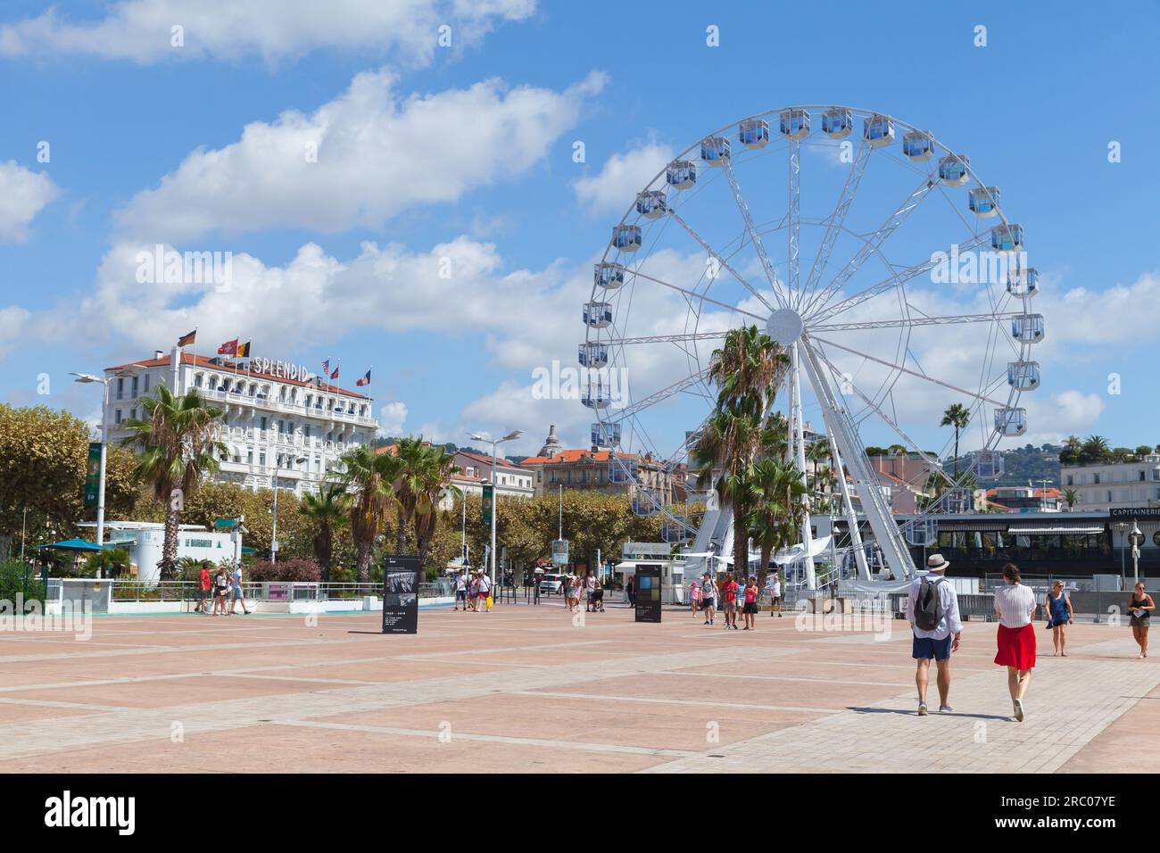 Cannes, Francia - 14 agosto 2018: I turisti camminano sull'Esplanade Pantiero di fronte alla ruota panoramica in una soleggiata giornata estiva Foto Stock