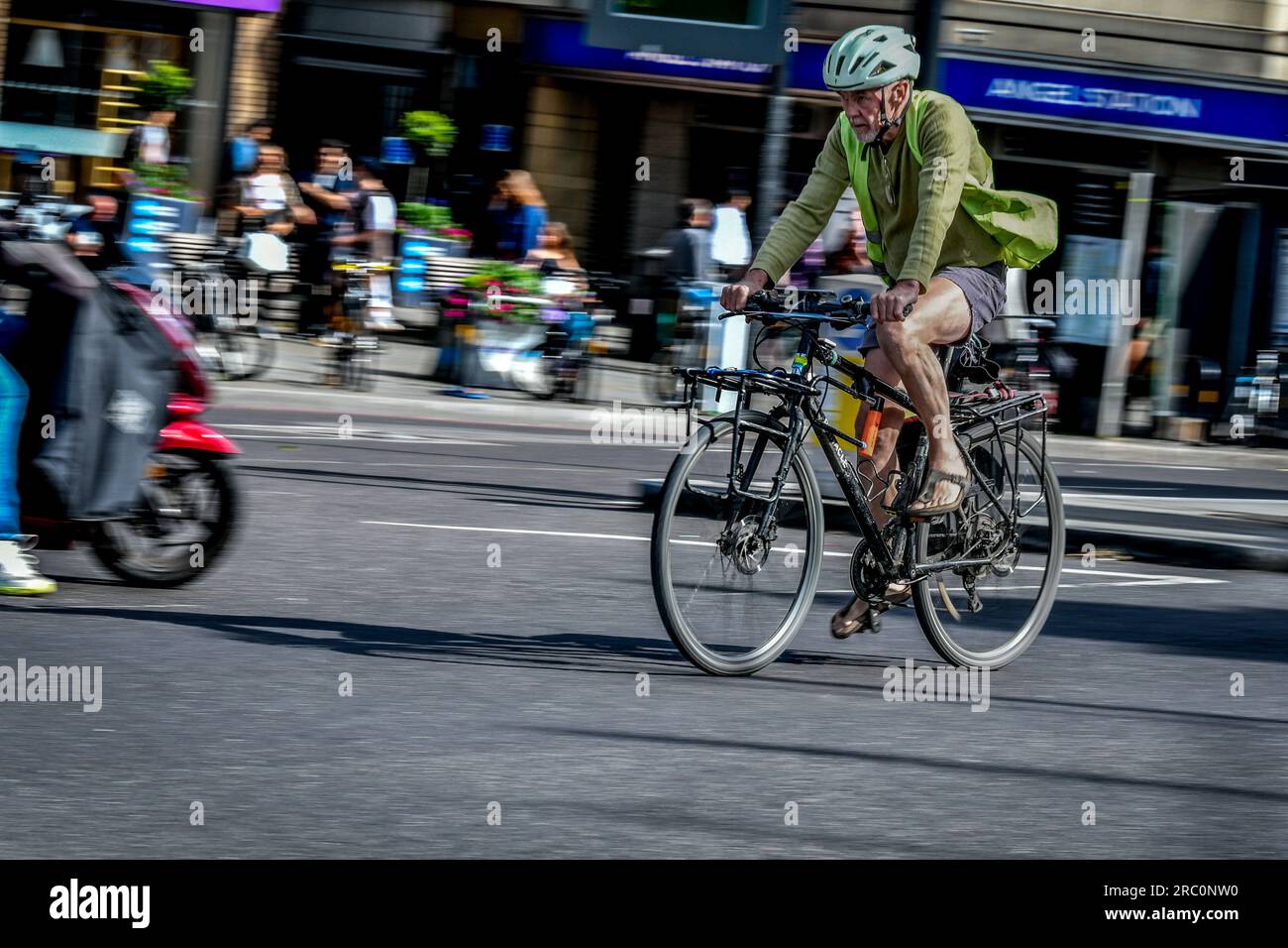 Anziano ciclista CrossingI slington Road, Islington, Londra, Regno Unito, Regno Unito Foto Stock