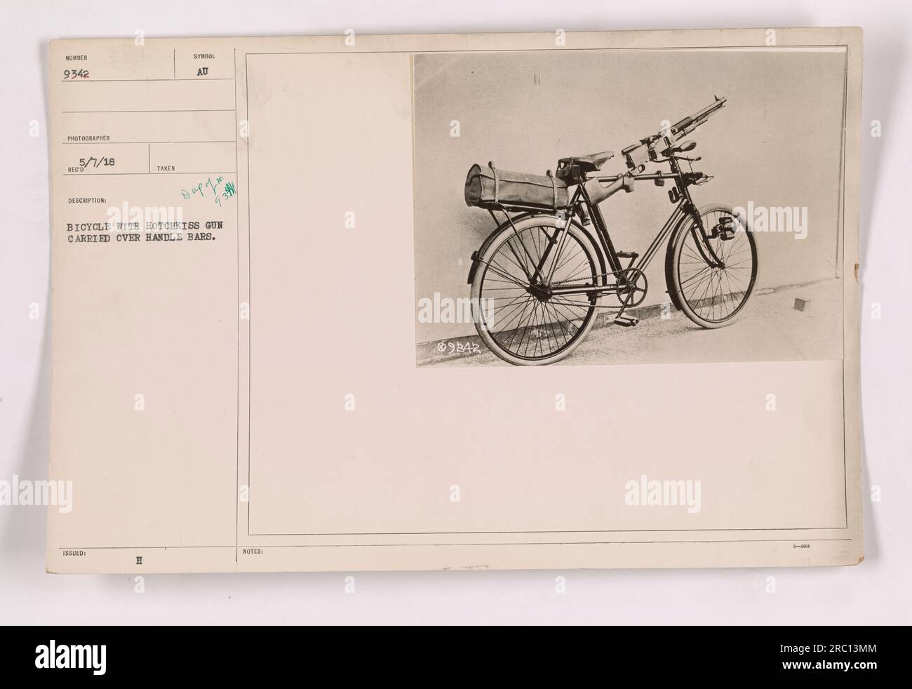 Un soldato che trasporta una pistola Hotchkiss su una bicicletta durante la prima guerra mondiale. Questa fotografia cattura l'intraprendenza e l'adattabilità del personale militare durante la guerra. La pistola è fissata saldamente al manubrio come mezzo di trasporto efficiente. Foto Stock