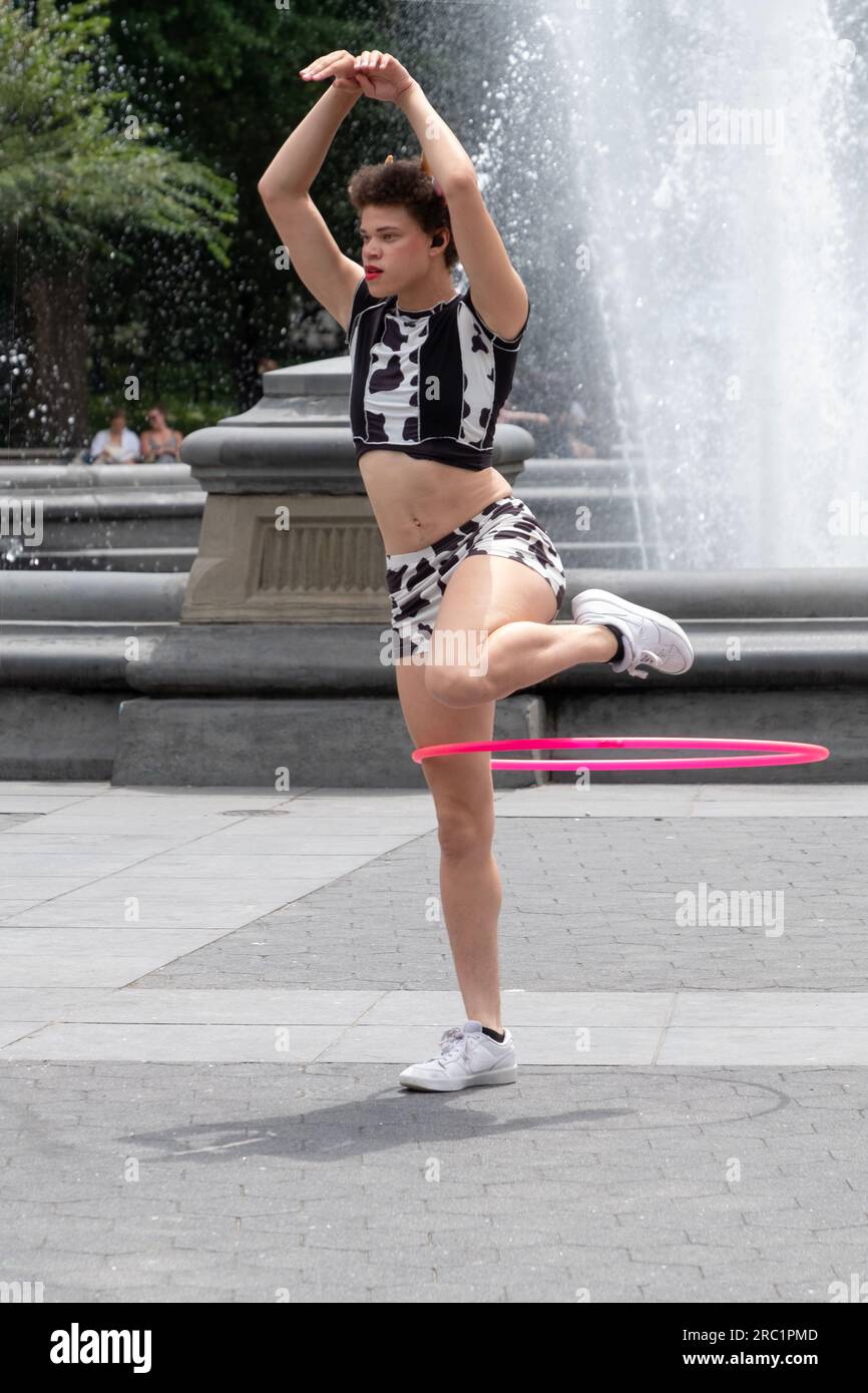 Ritratto di una superstar hula hoop che si esibisce vicino alla fontana nel Washington Square Park nel Greenwich Village a Manhattan, New York. Foto Stock