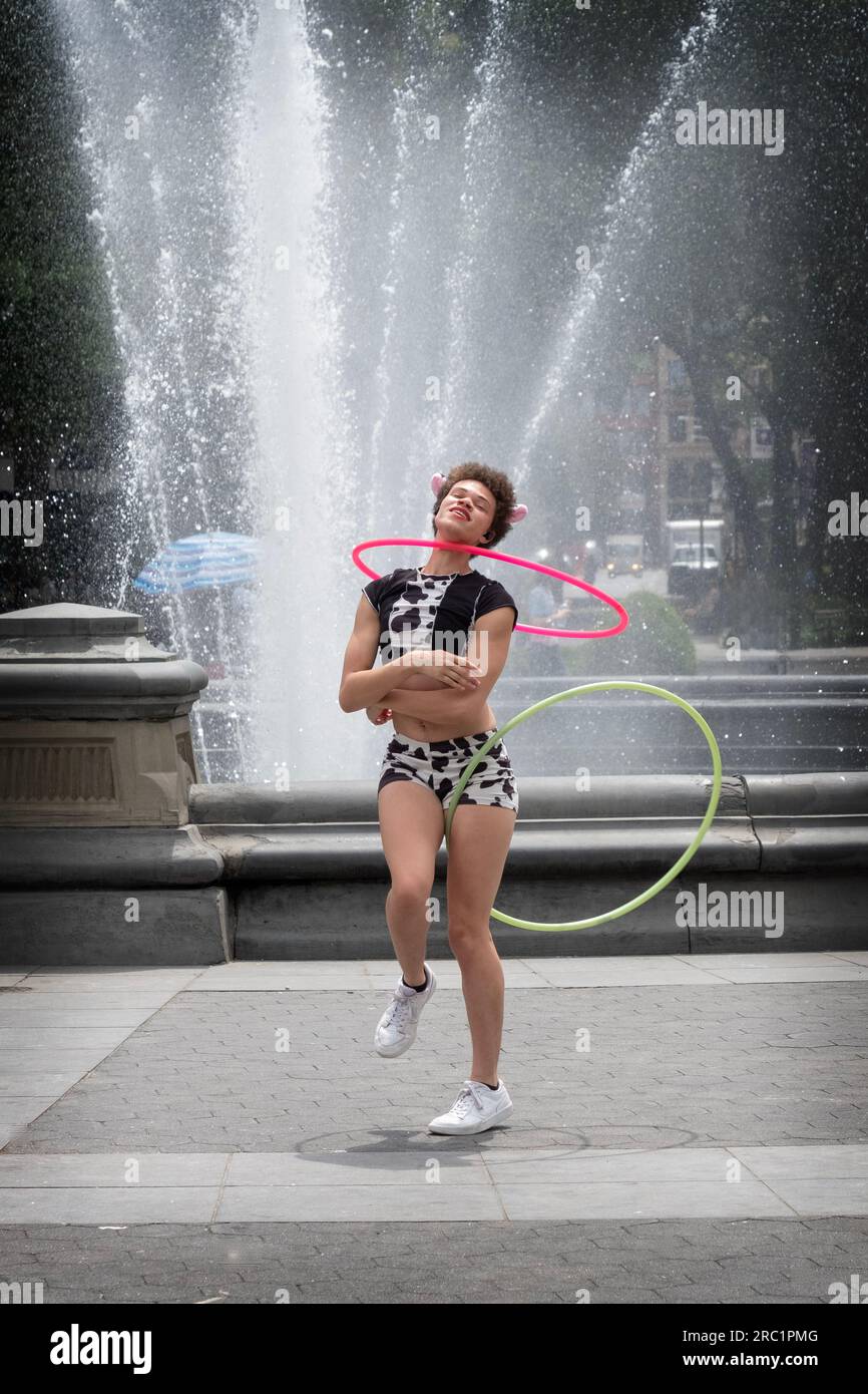 Ritratto di una superstar hula hoop che si esibisce vicino alla fontana nel Washington Square Park nel Greenwich Village a Manhattan, New York. Foto Stock
