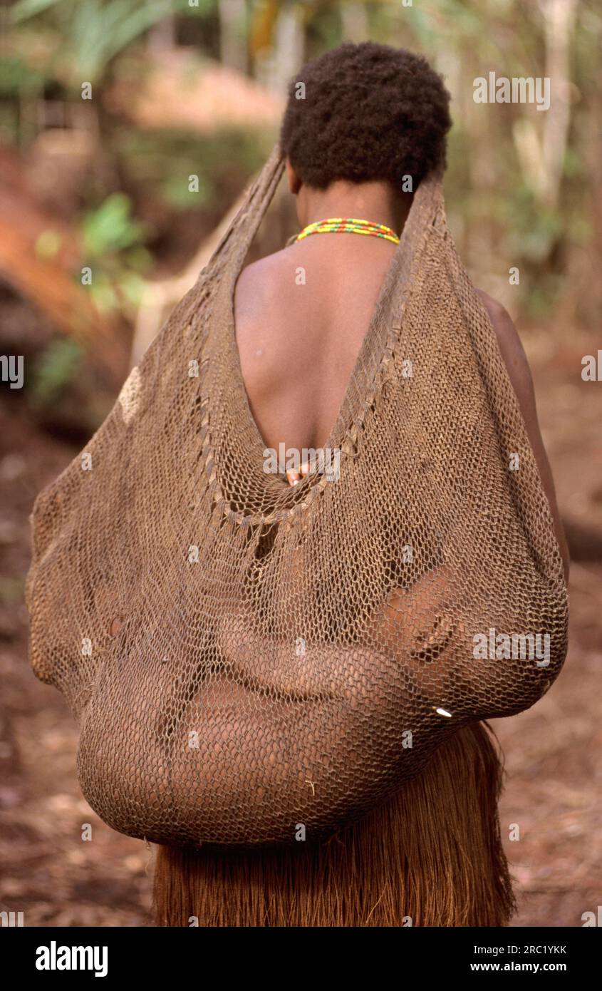 Donna che trasporta un bambino in rete, popolo Korowai, Papua Occidentale, nuova Guinea Occidentale, Irian-Jaya, Popolo degli alberi, Indonesia Foto Stock