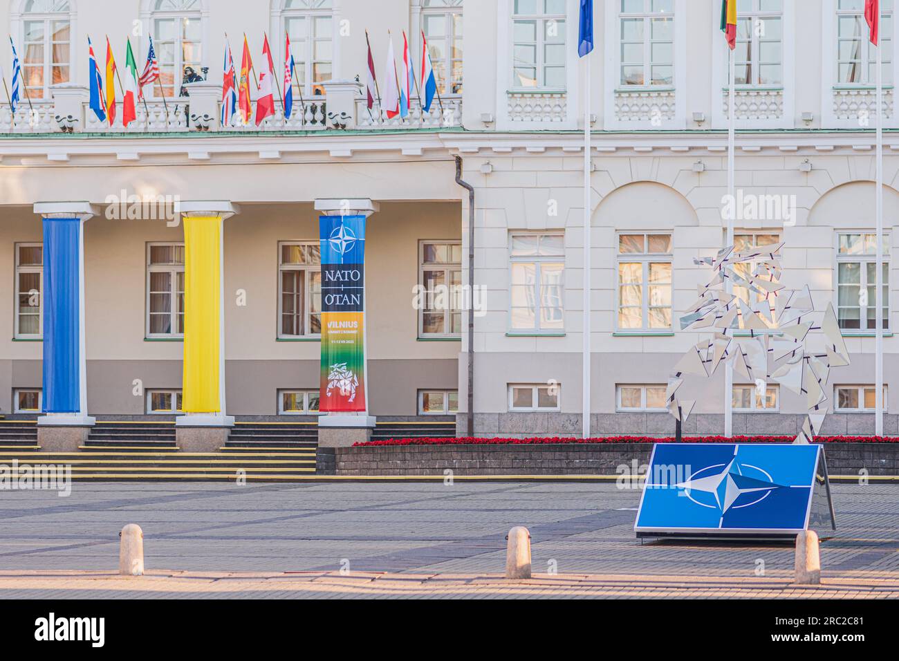 Logo e bandiere dei membri della NATO vicino al palazzo del Presidente che sventolano insieme alla bandiera dell'Ucraina durante la cena del vertice NATO 2023 nel centro di Vilnius Foto Stock
