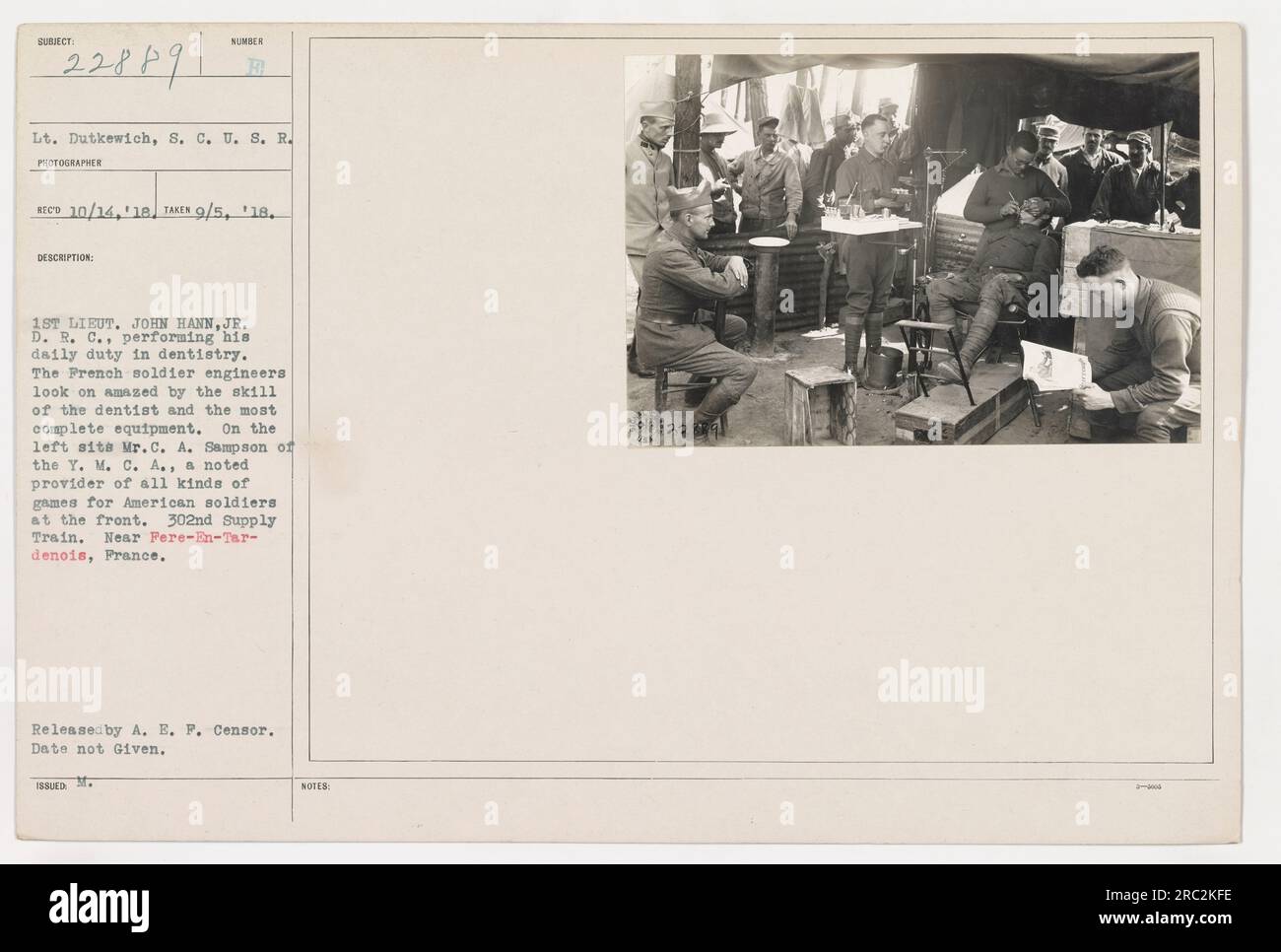Il primo tenente John Hann, Jr. Del Dental Reserve Corps, visto qui fornire cure dentistiche ai membri del 302nd Supply Train vicino a Fere-EN-Tardenois, Francia durante la prima guerra mondiale Gli ingegneri militari francesi osservano con stupore l'abilità del dentista e le attrezzature all'avanguardia. Signor C.A. Sampson of the Y.M.C.A. può essere visto a sinistra, noto per il suo contributo a vari giochi per i soldati americani. (Documento d'identità con foto: 111-SC-22889) Foto Stock