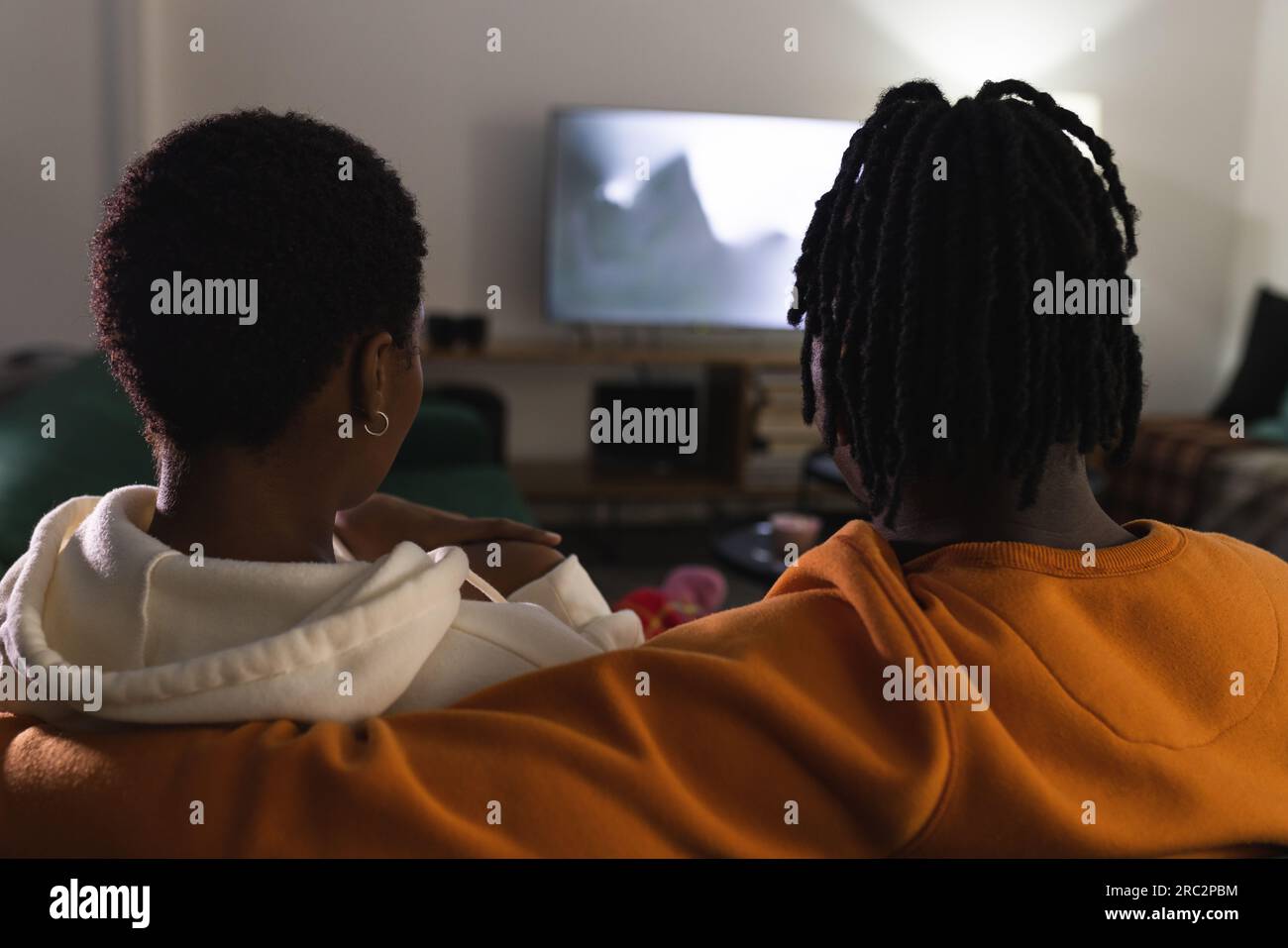 Coppia afroamericana che si rilassa a casa guardando un film spaventoso Foto Stock