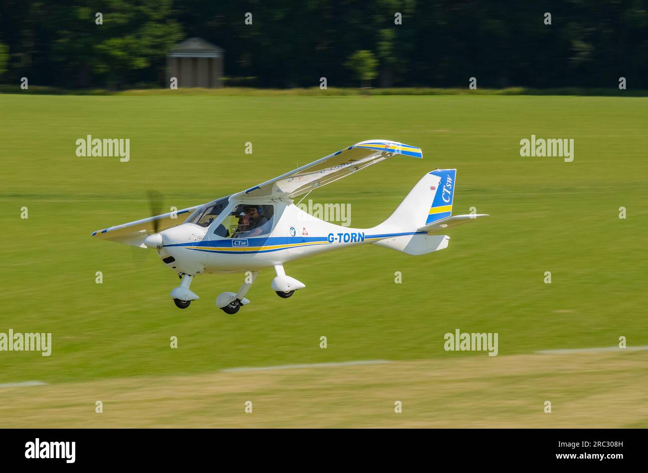 Flight Design CT-SW Plane G-TORN decolla presso la pista di atterraggio in erba di Heveningham nel Suffolk, Regno Unito. Pista d'erba alberata. Ultraleggero tedesco Foto Stock