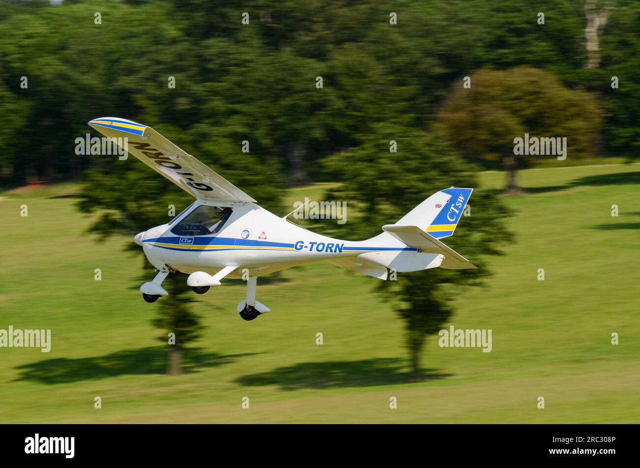 Flight Design CT-SW Plane G-TORN decolla presso la pista di atterraggio in erba di Heveningham nel Suffolk, Regno Unito. Pista d'erba alberata. Ultraleggero tedesco Foto Stock
