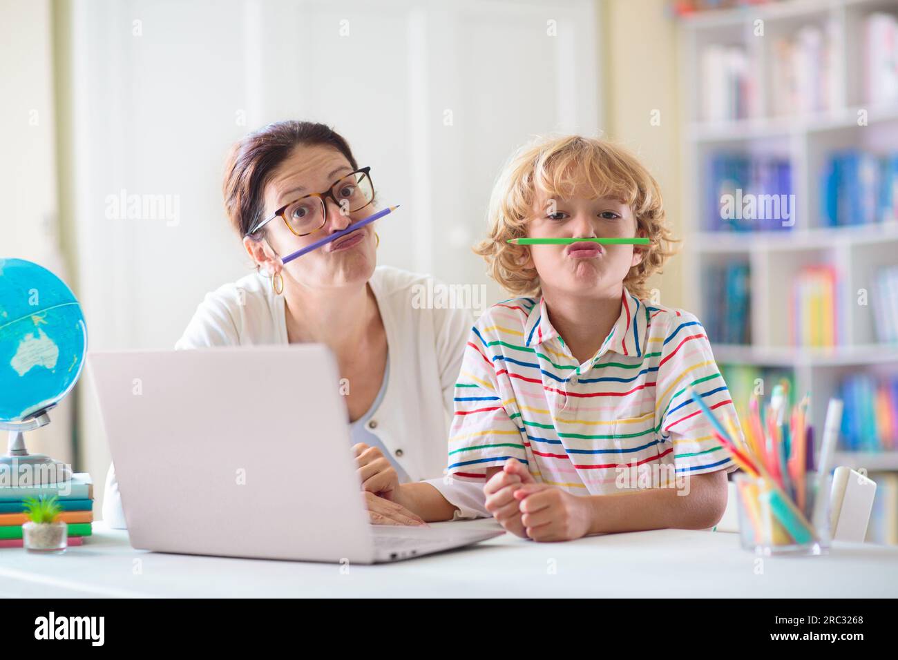 Bambino che fa i compiti a casa sul computer. Corso online. Homeschooling e apprendimento remoto. Bambino che legge sullo schermo del monitor. I bambini giocano al videogioco. Foto Stock