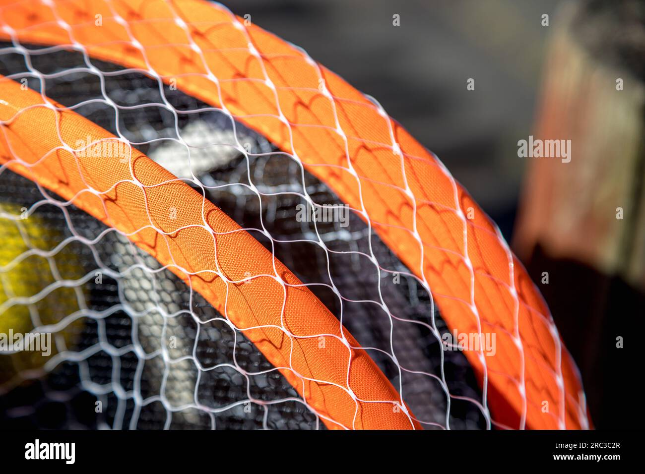 Immagine dettagliata di racchette da tennis e palla su uno sfondo molto sfocato, in una giornata molto soleggiata. Piccola profondità di campo. Splendido contrasto di texture. Foto Stock