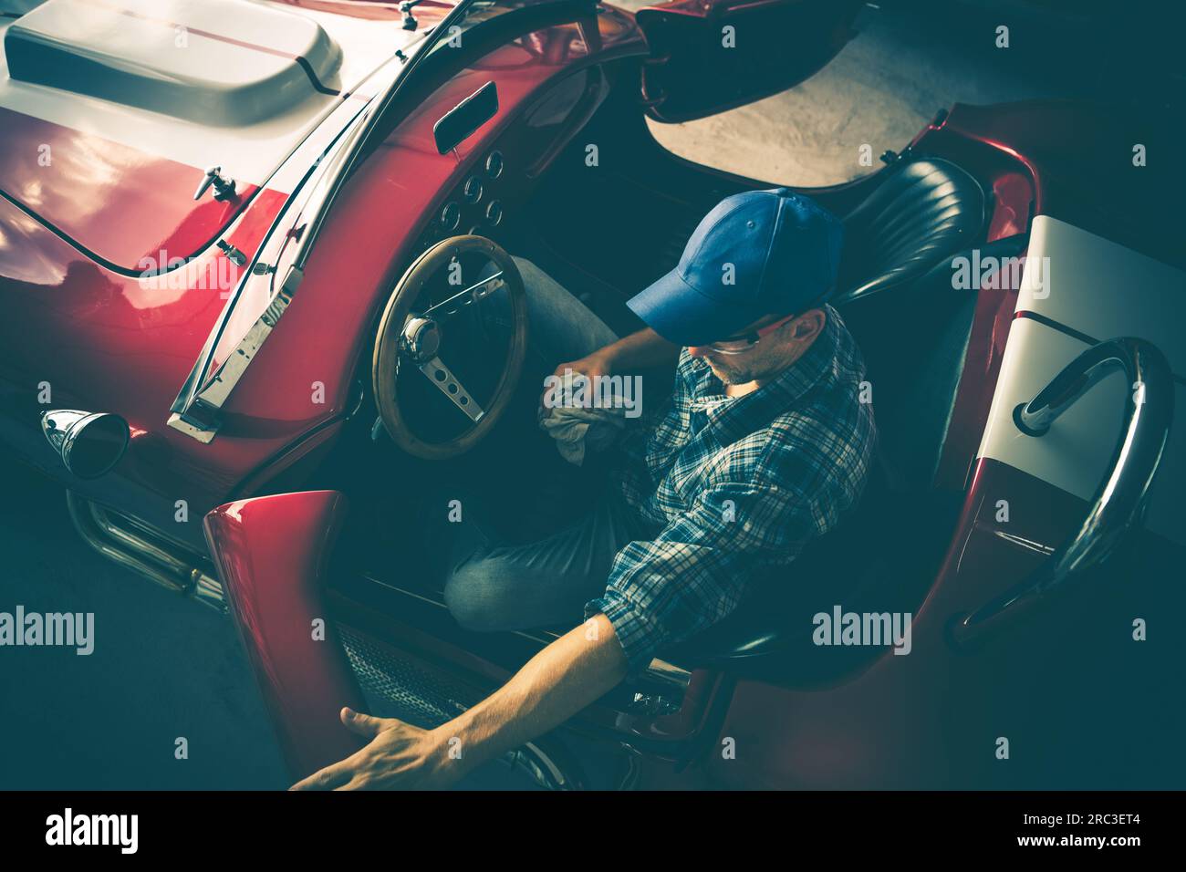 Tema Classic Cars Restoration. Meccanico professionale all'interno di un modello Classic convertibile Foto Stock