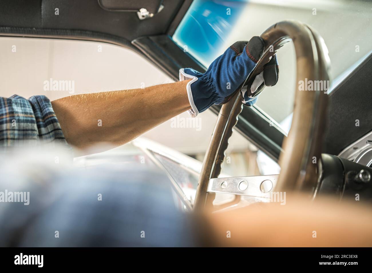 Meccanico di ripristino auto caucasiche dietro il volante di un'auto classica Foto Stock