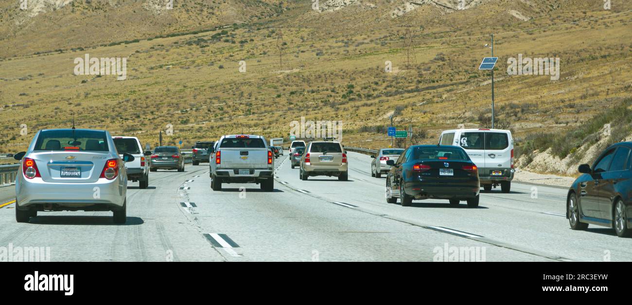 California, USA - 2 maggio 2017 - un grande flusso di auto si muove lungo l'autostrada in America, vista posteriore. Interstate Road in America, clima caldo, sole scottante. Autostrada americana con auto. Foto Stock