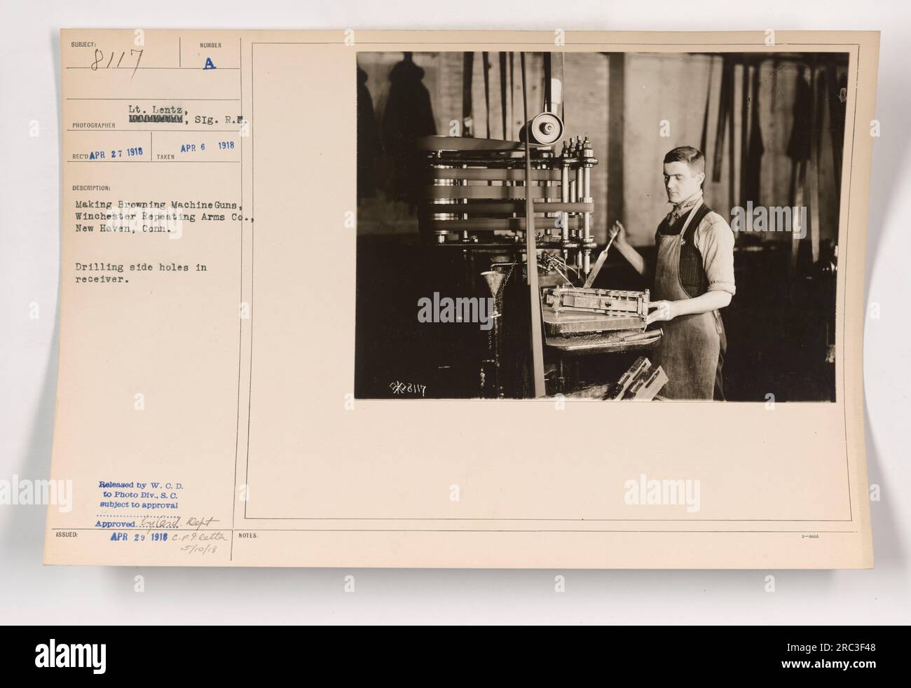 L'immagine mostra un fotografo, il tenente Lents della 1000th Signals Reserve, che cattura il processo di fabbricazione di Browning Machine Guns a Winchester Repeating Arms Co. A New Haven, Connecticut il 6 aprile 1918. L'attività specifica illustrata è la foratura di fori laterali nel ricevitore della pistola. La fotografia è stata rilasciata alla Photo Division sotto l'autorizzazione del Dipartimento della Guerra. Foto Stock