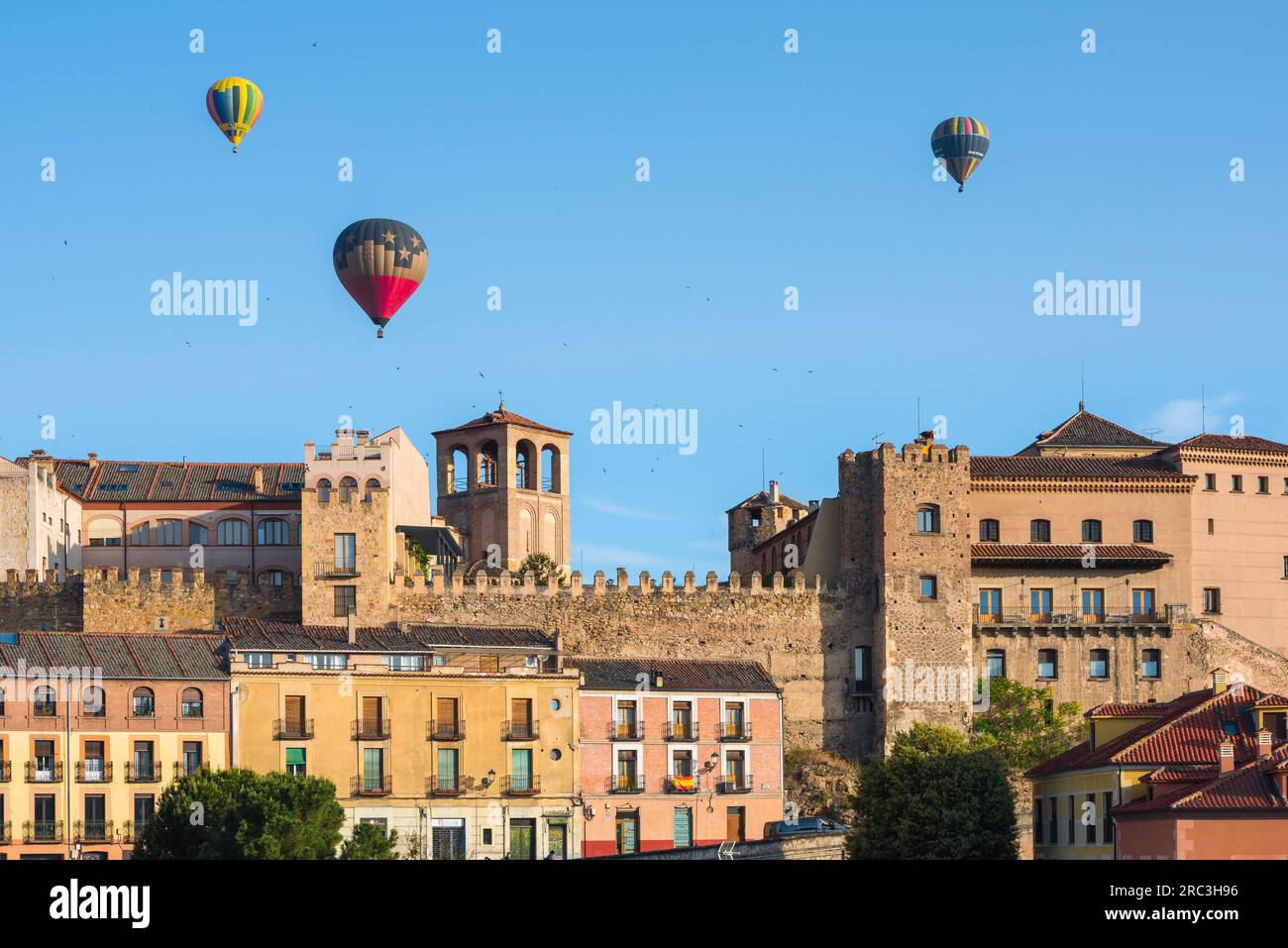 Viaggio avventuroso, vista in estate delle mongolfiere che galleggiano sullo storico quartiere della città vecchia di Segovia, nella Spagna centrale Foto Stock
