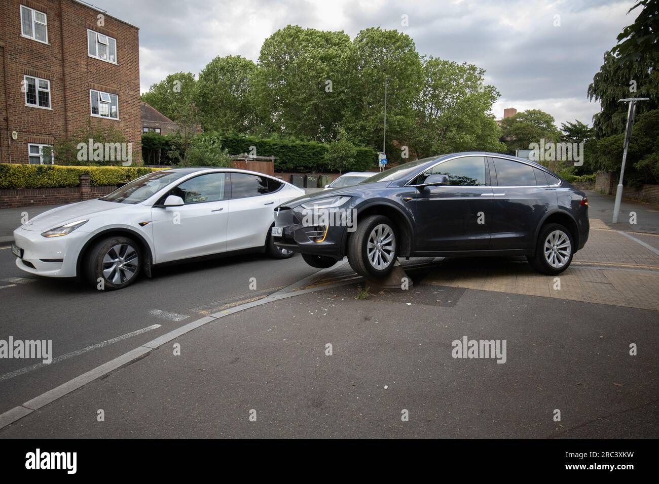 Tesla rimane intrappolata dopo aver guidato accidentalmente su un dissuasore stradale all'angolo di una strada residenziale a South Wimbledon, Londra, Inghilterra, Regno Unito Foto Stock