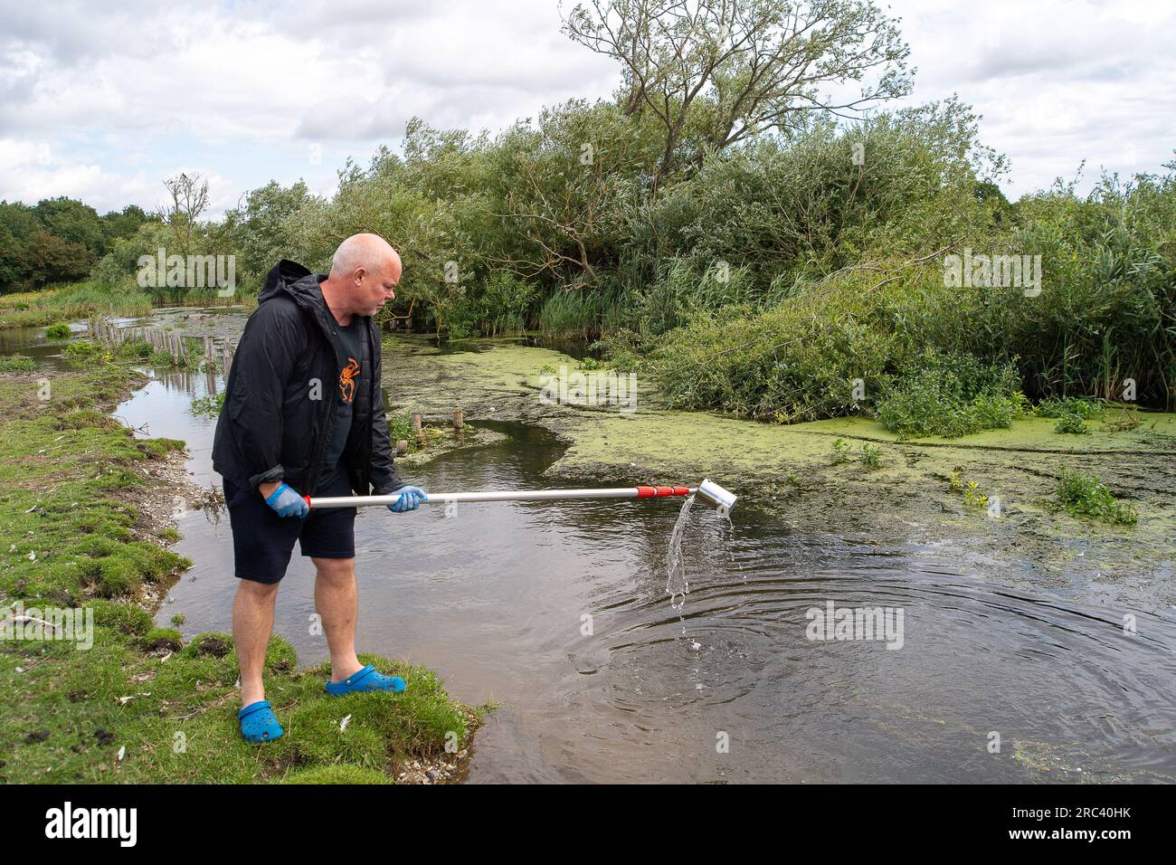 Dorney, Regno Unito. 12 luglio 2023. I cittadini scienziati Dave e Jacqui Wallace, che lavorano per conto dell'Henley River Action Group, oggi stavano facendo dei test sui livelli di inquinamento idrico a Roundmoor Ditch (nella foto) a Dorney Common nel Buckinghamshire utilizzando le apparecchiature di test fornite da Earthwatch Europe. Il Thames Water Event Duration Monitoring (EDM) mostra che l'acqua del Tamigi è stata scaricata nel Roundmoor Ditch dai vicini impianti di trattamento delle acque reflue del Thames Water Slough; tuttavia, l'ultimo scarico EDM è stato registrato il 21 gennaio 2023. I risultati dei test di oggi sull'acqua nuvolosa a Roundmoor Ditch Foto Stock