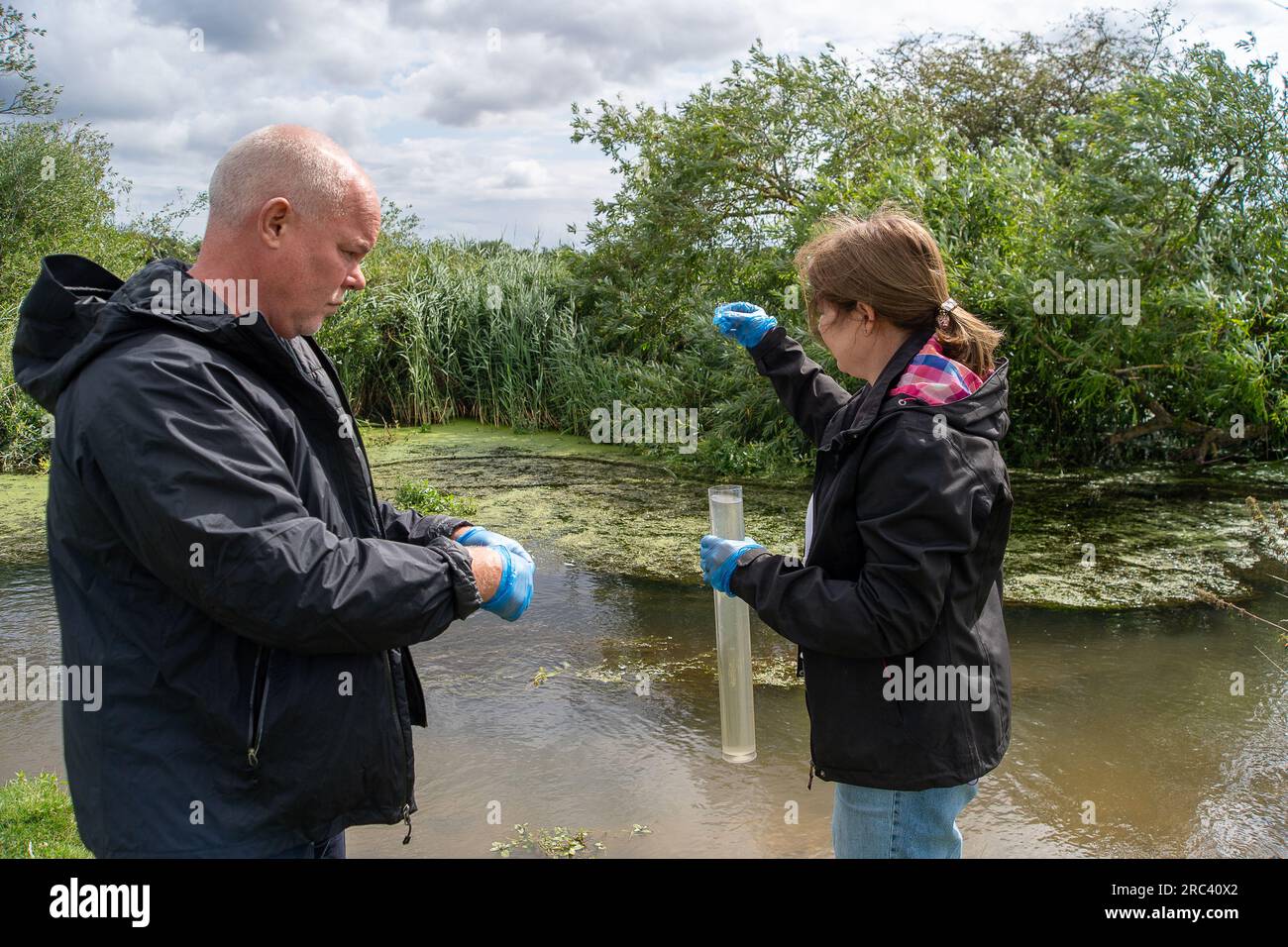 Dorney, Regno Unito. 12 luglio 2023. I cittadini scienziati Dave e Jacqui Wallace, che lavorano per conto dell'Henley River Action Group, oggi stavano facendo dei test sui livelli di inquinamento idrico a Roundmoor Ditch (nella foto) a Dorney Common nel Buckinghamshire utilizzando le apparecchiature di test fornite da Earthwatch Europe. Il Thames Water Event Duration Monitoring (EDM) mostra che l'acqua del Tamigi è stata scaricata nel Roundmoor Ditch dai vicini impianti di trattamento delle acque reflue del Thames Water Slough; tuttavia, l'ultimo scarico EDM è stato registrato il 21 gennaio 2023. I risultati dei test di oggi sull'acqua nuvolosa a Roundmoor Ditch Foto Stock