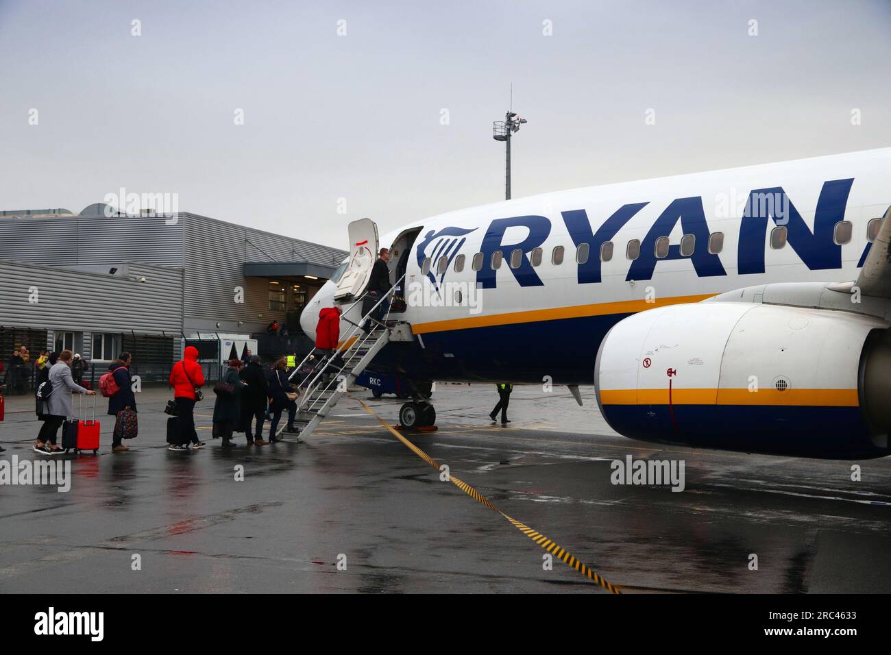 BEAUVAIS, FRANCIA - 11 DICEMBRE 2019: I passeggeri salgono a bordo del Boeing 737 sotto la pioggia della compagnia aerea low cost Ryanair all'aeroporto di Beauvais, Francia. Imbarco da parte di sta Foto Stock
