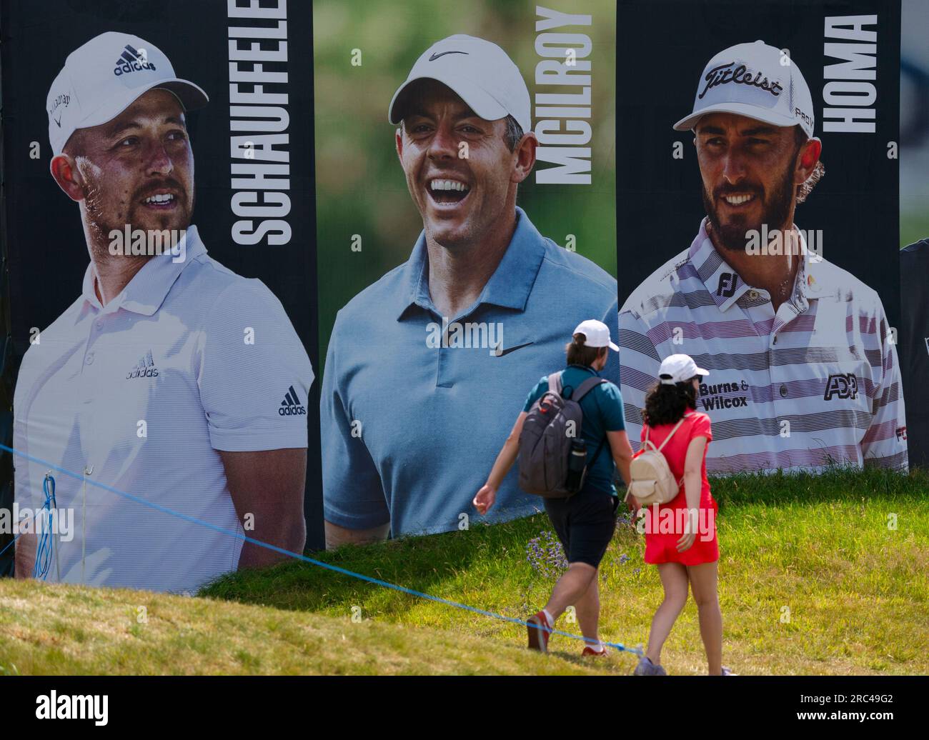 North Berwick, East Lothian, Scozia, Regno Unito. 12 luglio 2023. Gli spettatori camminano davanti a un grande cartellone al Genesis Scottish Open al Renaissance Club di North Berwick. Iain Masterton/Alamy Live News Foto Stock