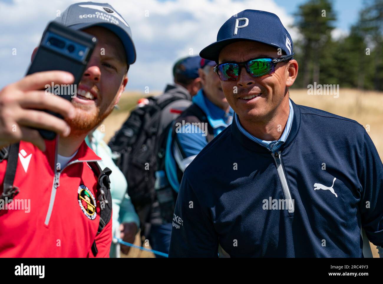 North Berwick, East Lothian, Scozia, Regno Unito. 12 luglio 2023. Rickie Fowler posa per un selfie con un fan al Genesis Scottish Open al Renaissance Club di North Berwick. Iain Masterton/Alamy Live News Foto Stock
