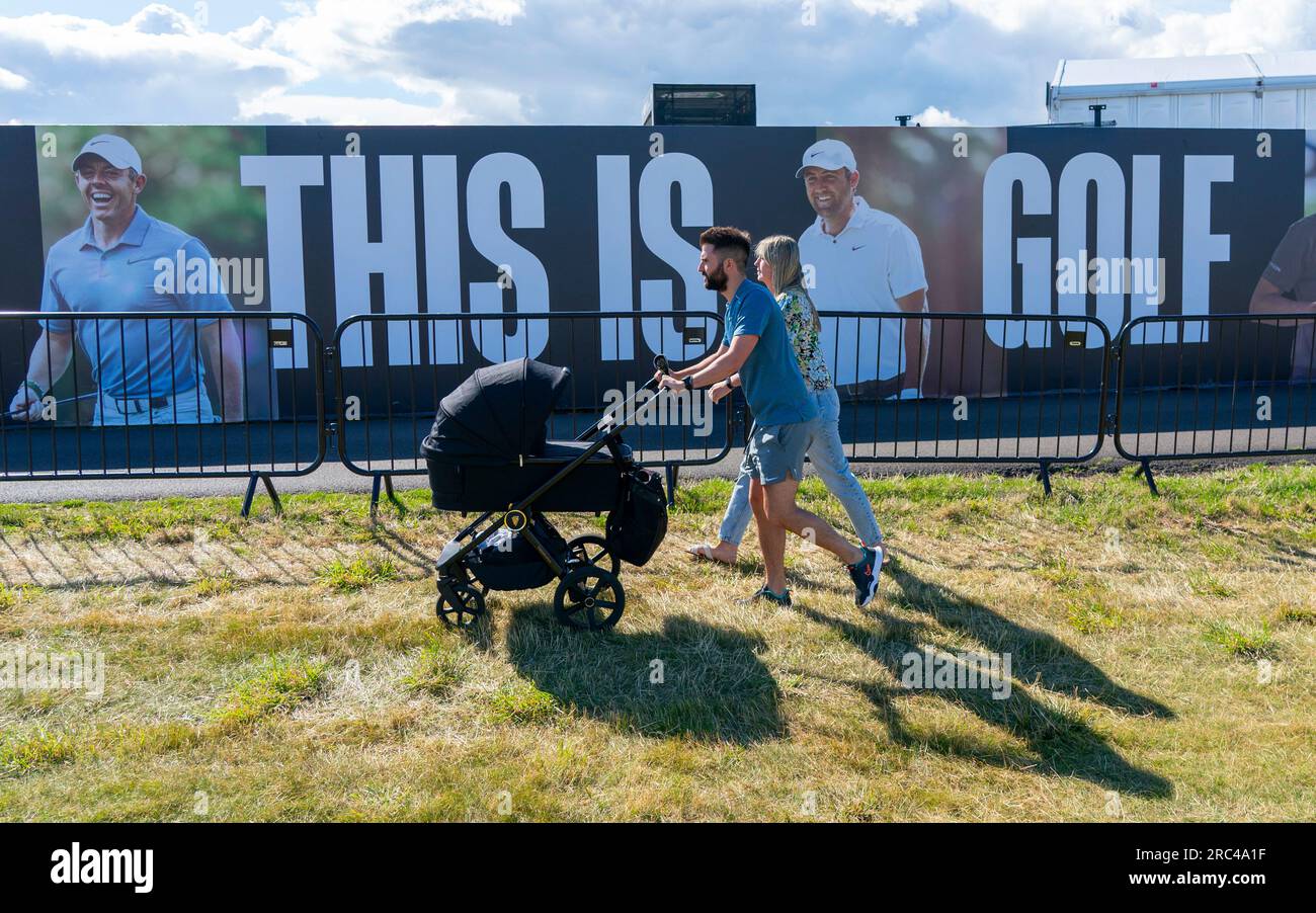 North Berwick, East Lothian, Scozia, Regno Unito. 12 luglio 2023. Gli spettatori camminano davanti a un grande cartellone al Genesis Scottish Open al Renaissance Club di North Berwick. Iain Masterton/Alamy Live News Foto Stock