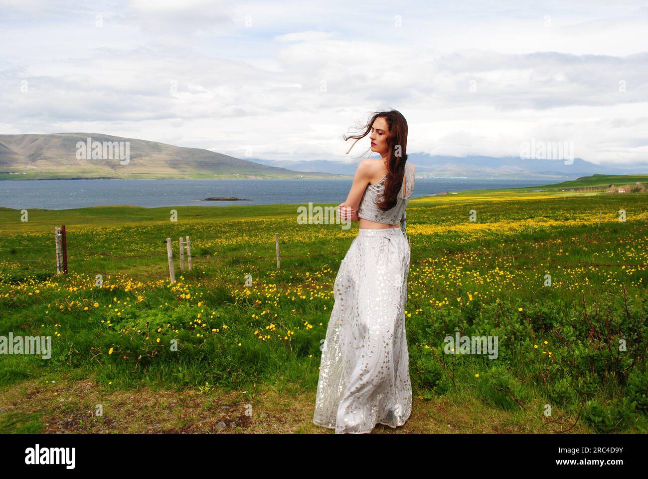 Una donna si trova in un campo vicino a Mossfellsbaer, Islanda Foto Stock