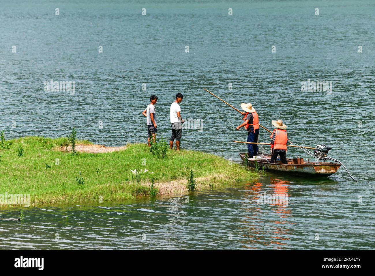 (230712) -- WENG'AN, 12 luglio 2023 (Xinhua) -- Lu Xiyong e hanno tenuto un discorso maoying con gli abitanti locali sulla protezione ambientale dal fiume Wujiang nella città di Zhucang della contea di Weng'an, nella provincia di Guizhou della Cina sud-occidentale, 11 luglio 2023. Lu e Ran sono abitanti del villaggio che sono cresciuti lungo il fiume Wujiang e si sono sposati nel 1986. Per decenni, la coppia prese l'iniziativa di ripulire i rifiuti galleggianti lungo il fiume Wujiang e promuovere la protezione ambientale mentre lavorava sui traghetti. Sotto l'influenza della coppia, più di dieci abitanti locali hanno partecipato alla wor volontaria Foto Stock