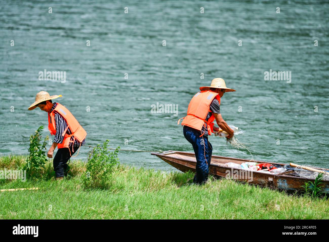 (230712) -- WENG'AN, 12 luglio 2023 (Xinhua) -- Lu Xiyong e Ran Maoying pick up spazzatura sulla riva del fiume Wujiang nella Zhucang Township della contea di Weng'an, nella provincia di Guizhou della Cina sud-occidentale, 11 luglio 2023. Lu e Ran sono abitanti del villaggio che sono cresciuti lungo il fiume Wujiang e si sono sposati nel 1986. Per decenni, la coppia prese l'iniziativa di ripulire i rifiuti galleggianti lungo il fiume Wujiang e promuovere la protezione ambientale mentre lavorava sui traghetti. Sotto l'influenza della coppia, più di dieci abitanti del villaggio hanno partecipato al lavoro volontario dei dirigenti del fiume Wujiang Foto Stock