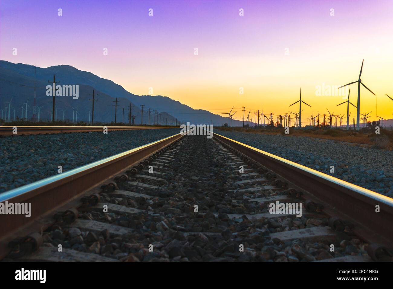 Un tramonto mozzafiato sui binari della Yuma Subdivision di Union Pacific, dirigendosi a nord-ovest parallelo ai mulini a vento di Palm Springs. Foto Stock