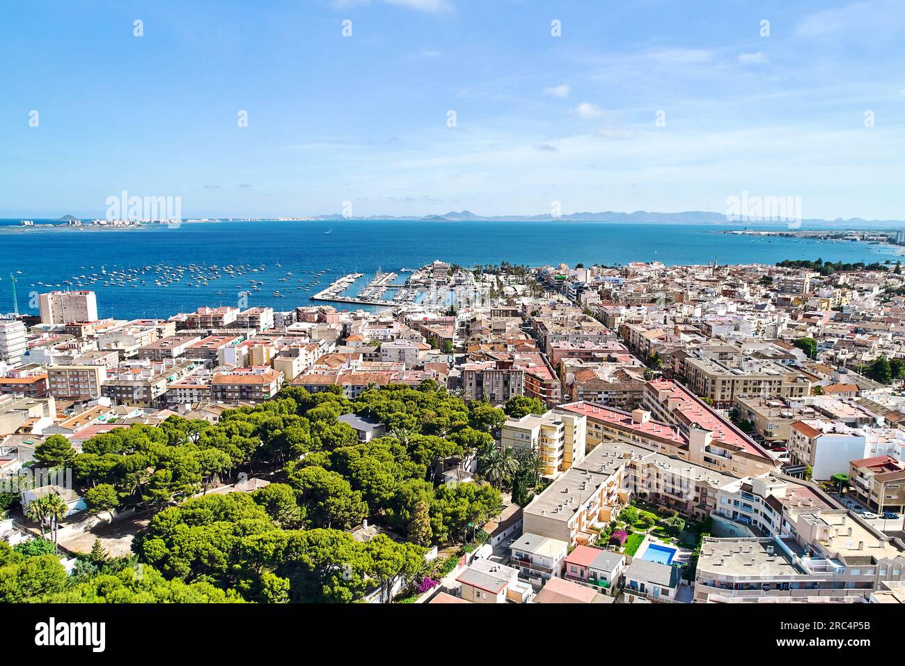 Vista panoramica diurna dei tetti della città di San Pedro del Pinatar e vista del Mar Mediterraneo con porticciolo porto attraccato da navi nautiche, drone Point of vi Foto Stock