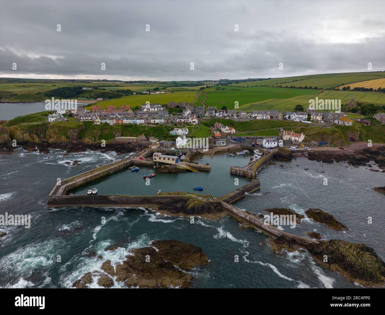 Foto aerea con drone di St Abbs a Berwickshiree, Scozia. St Abbs è un piccolo villaggio costiero con un porto. Foto Stock