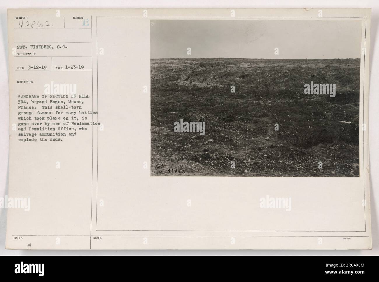 L'immagine mostra una vista panoramica di una sezione della Collina 304 a Mosa, in Francia, durante la prima guerra mondiale. Il terreno è pesantemente danneggiato dalle precedenti battaglie. Gli uomini dell'ufficio di bonifica e demolizione sono visti salvare munizioni ed esplodere ordigni inesplosi. Foto Stock