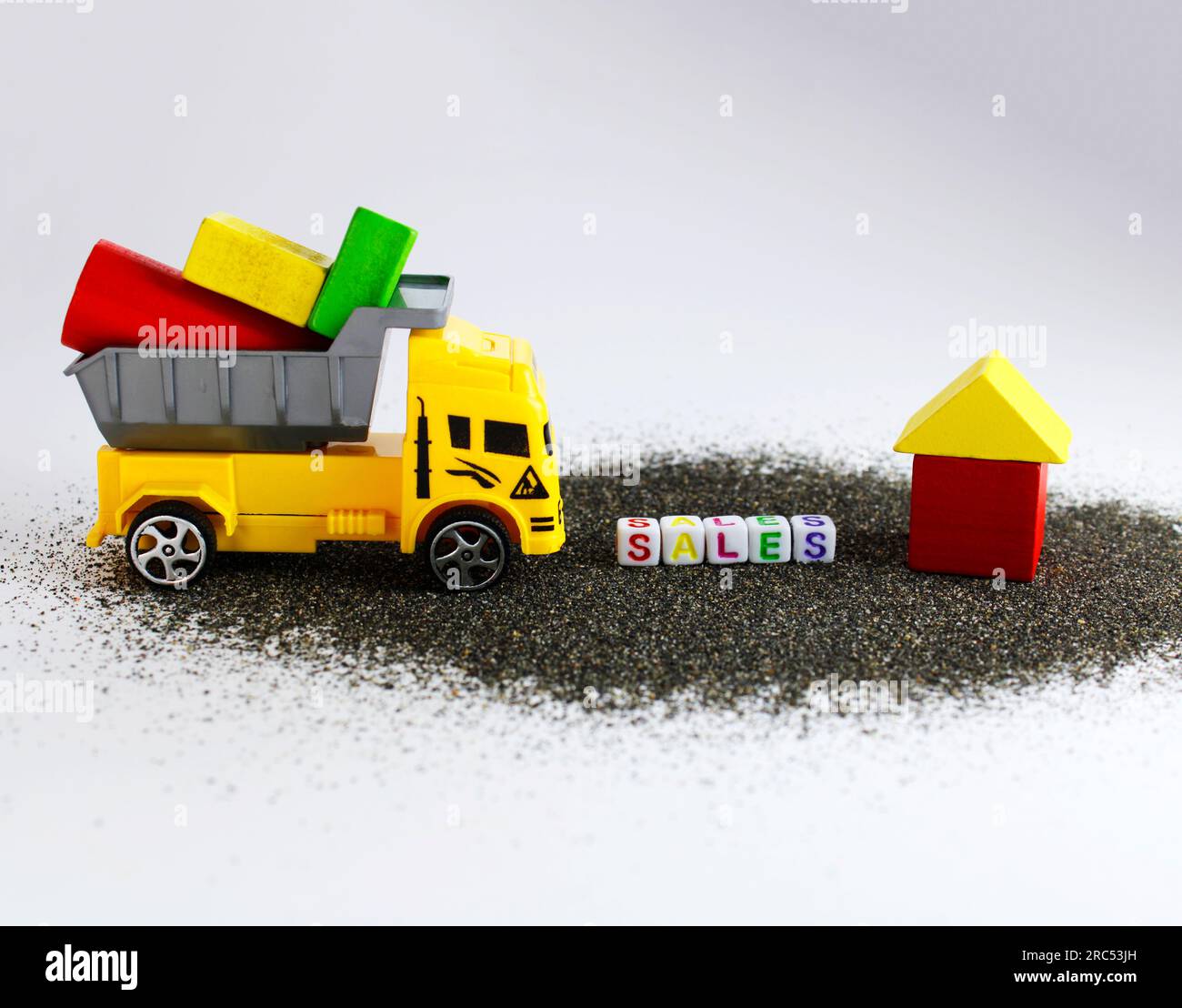 Camion da carico con figure geometriche per costruire case che saranno vendute Foto Stock